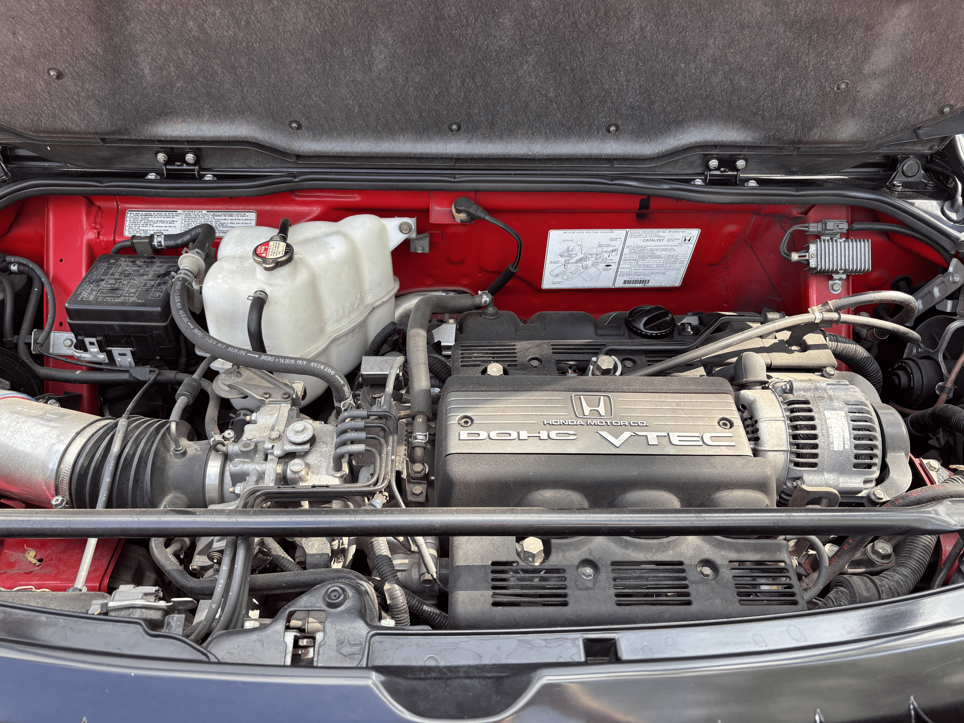 A close up of a car engine with the hood up
