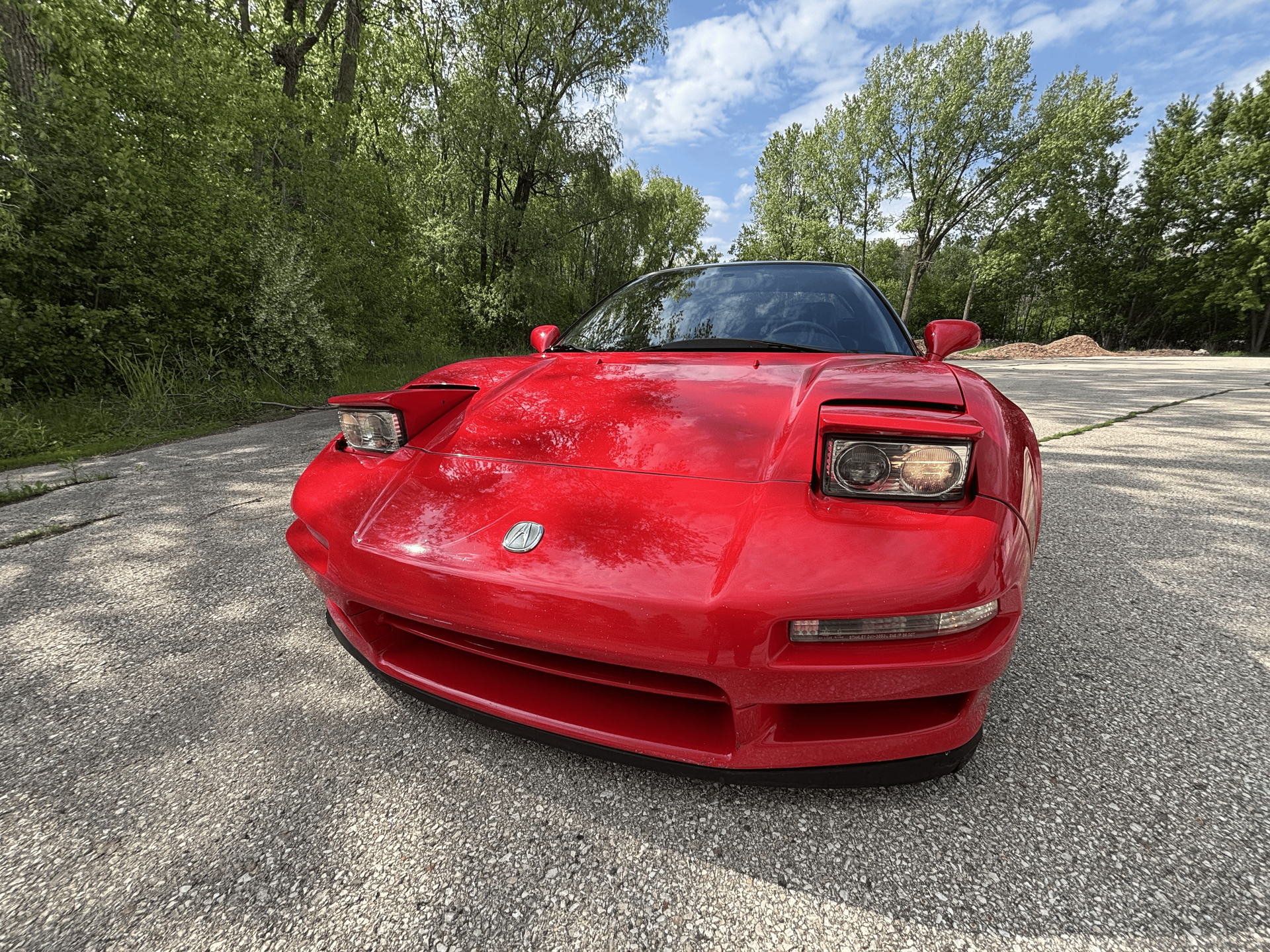 A red sports car is parked on the side of a road.