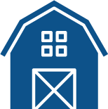 A blue barn with a white door and windows.