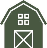 A green barn with a white door and a white roof.