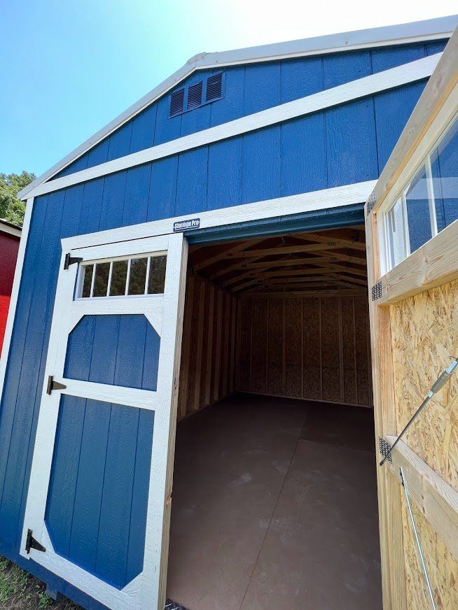 A blue and white shed with the door open.