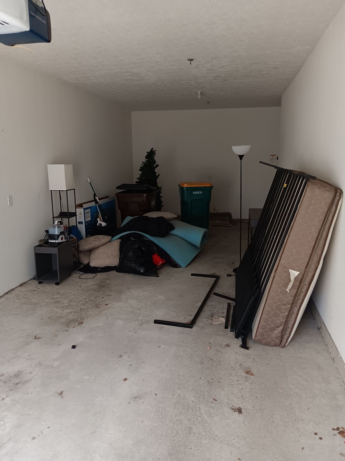 A room with a lot of furniture and a mattress on the floor.