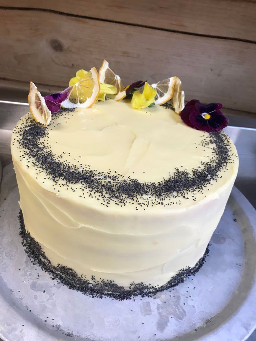 Cake with cream decoration and flowers around the top
