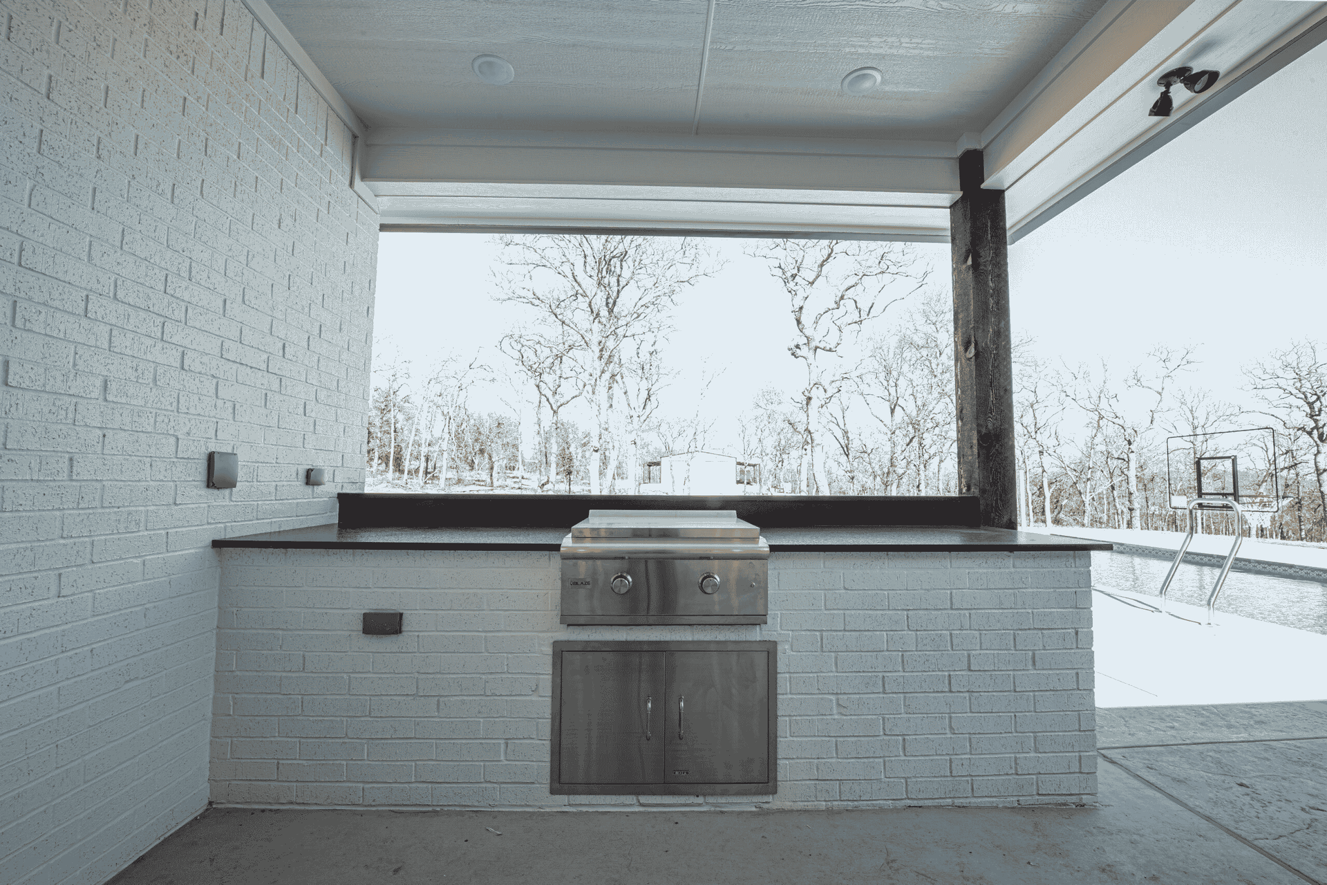 A kitchen with a grill and a large window.