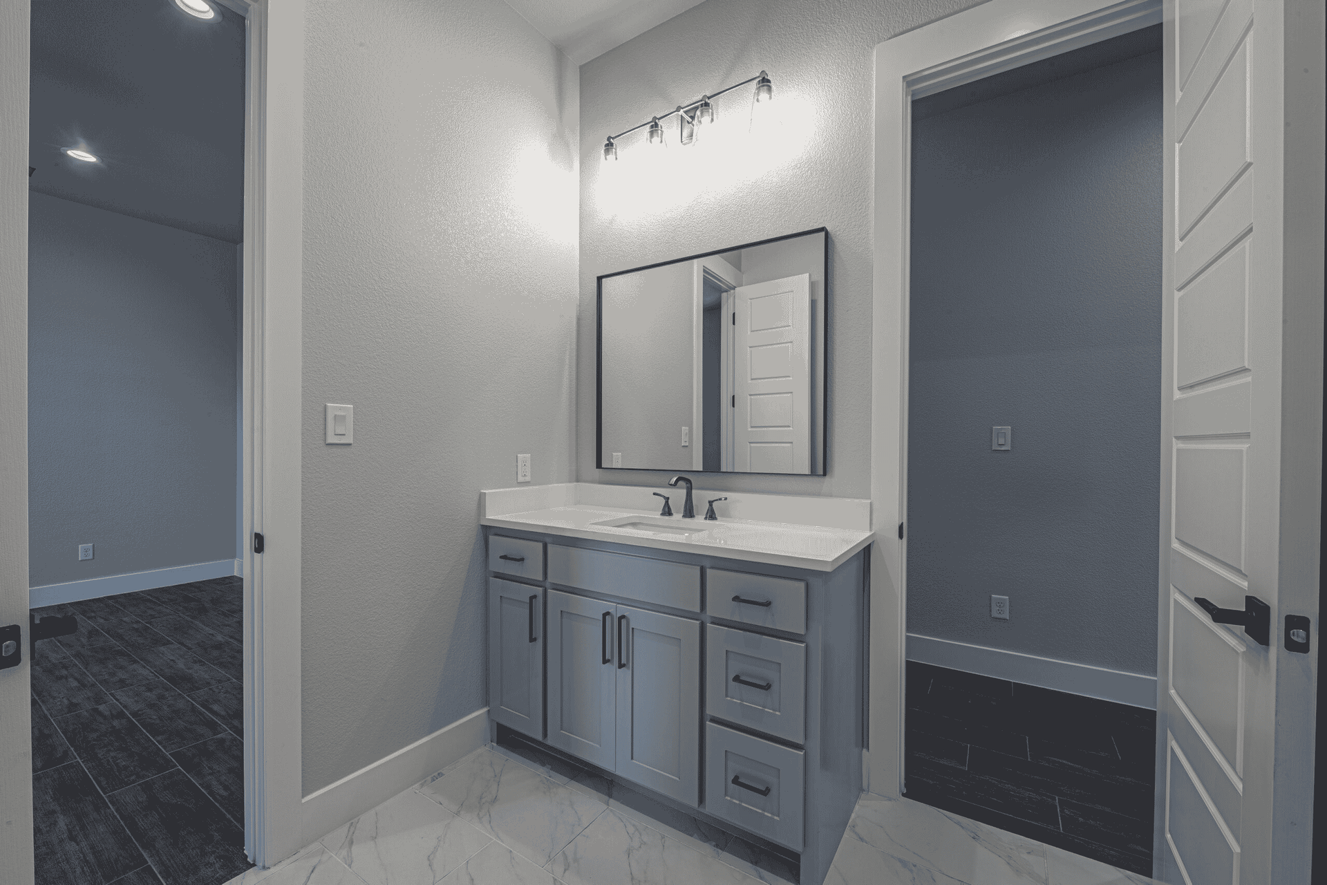 A bathroom with a sink , mirror and drawers.