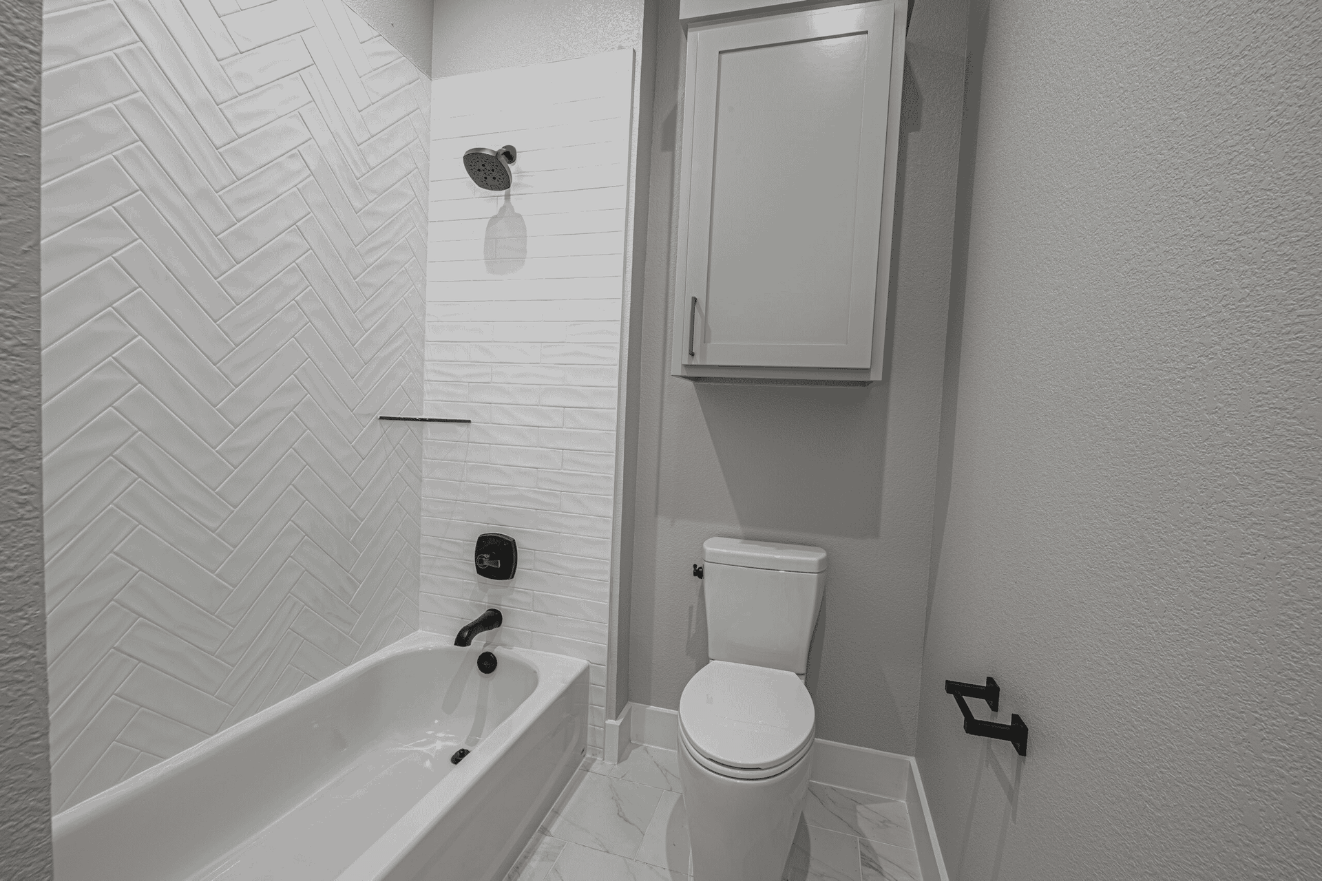 A bathroom with a toilet , bathtub and shower.