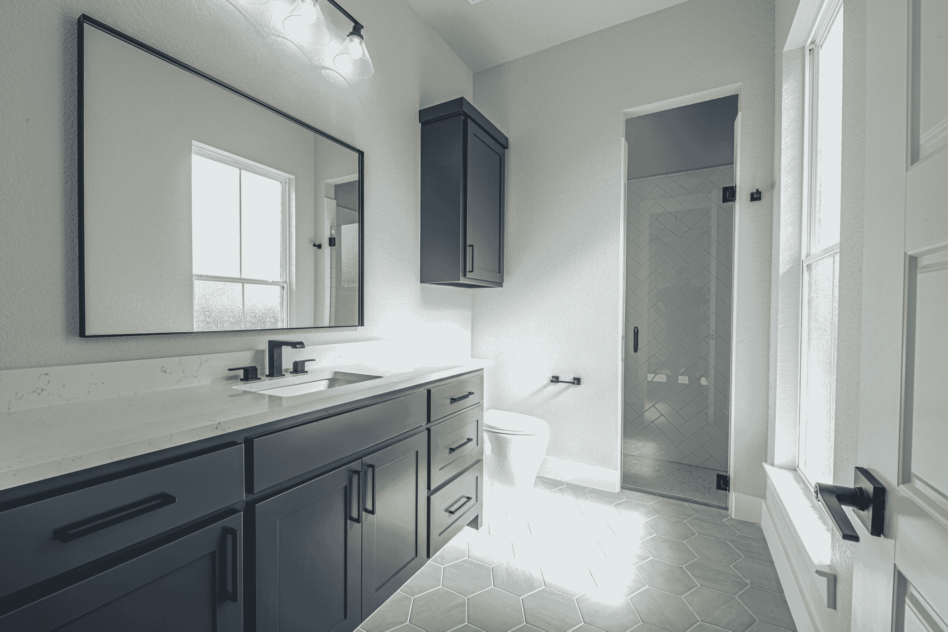 A bathroom with two sinks , a toilet , and a large mirror.