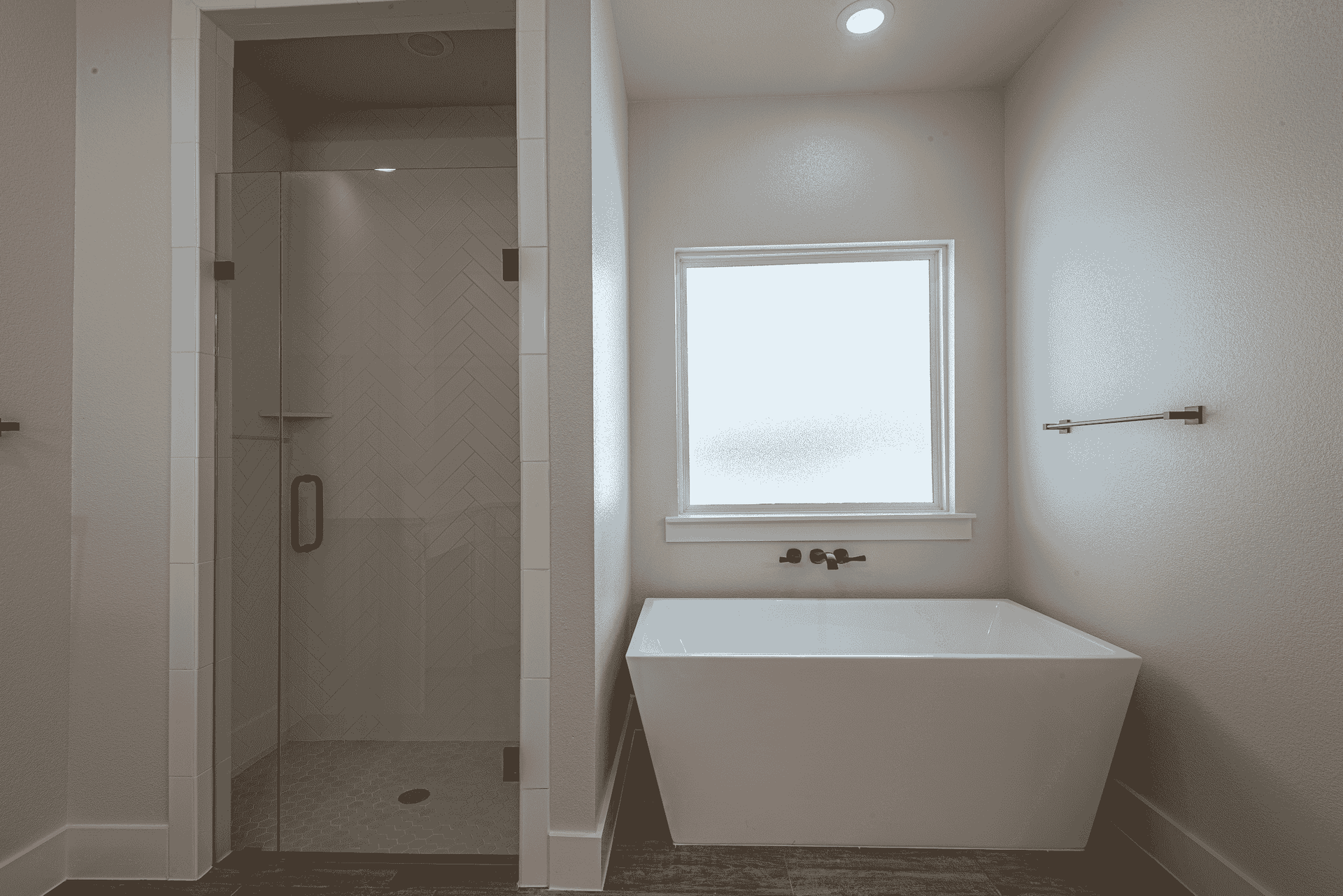 A bathroom with a tub , shower and window.