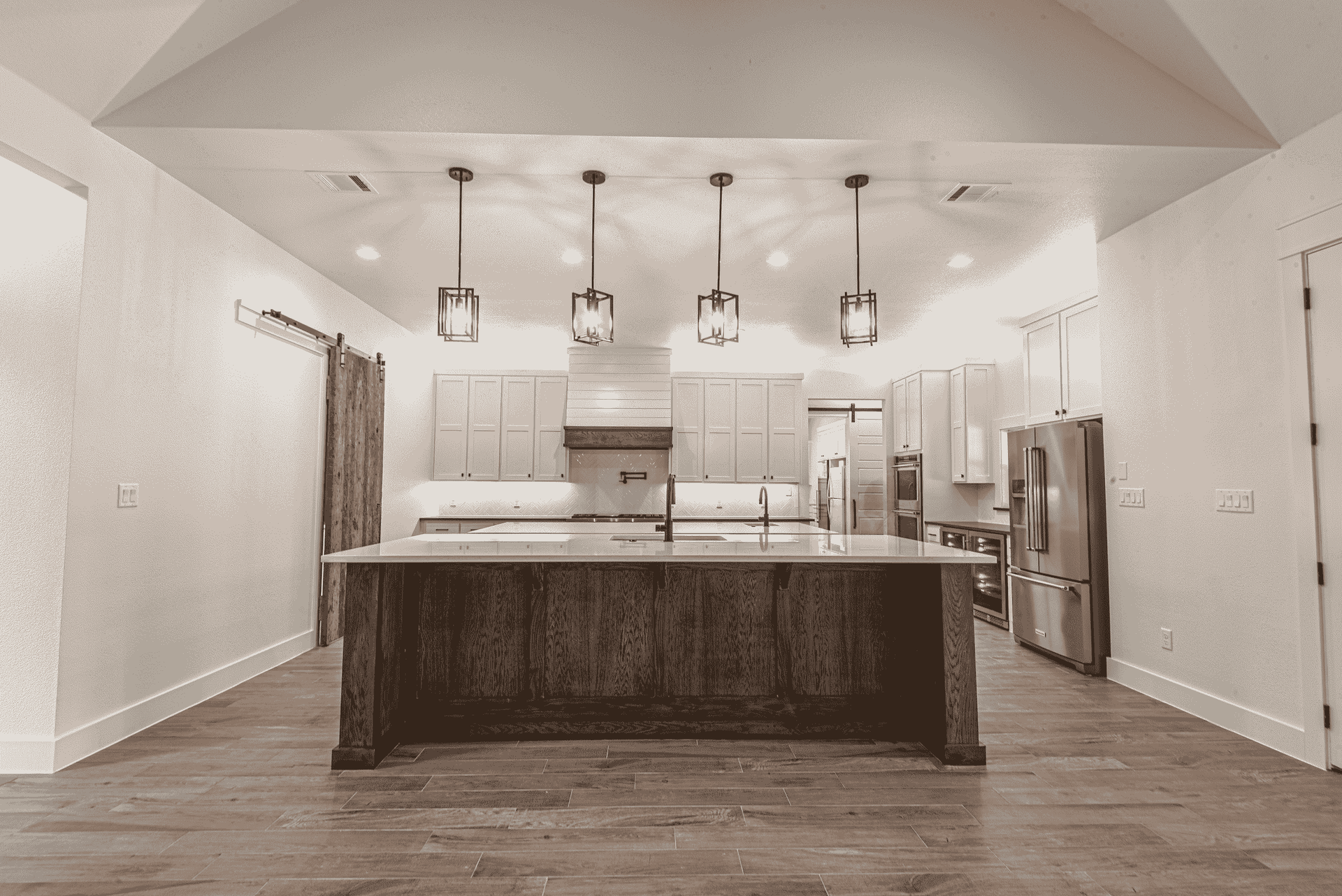 A black and white photo of a kitchen with a large island in the middle.