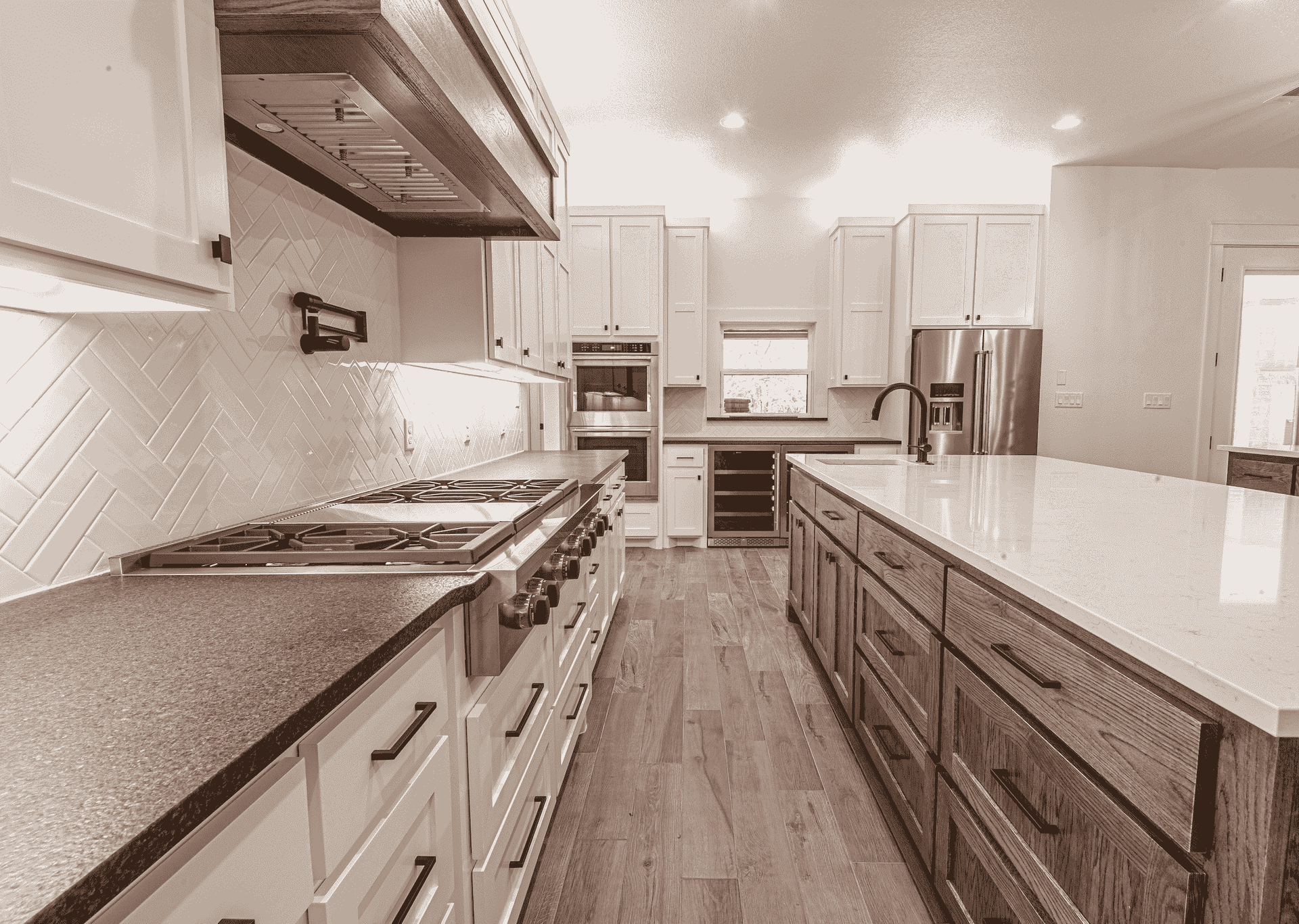A black and white photo of a kitchen with a large island in the middle.