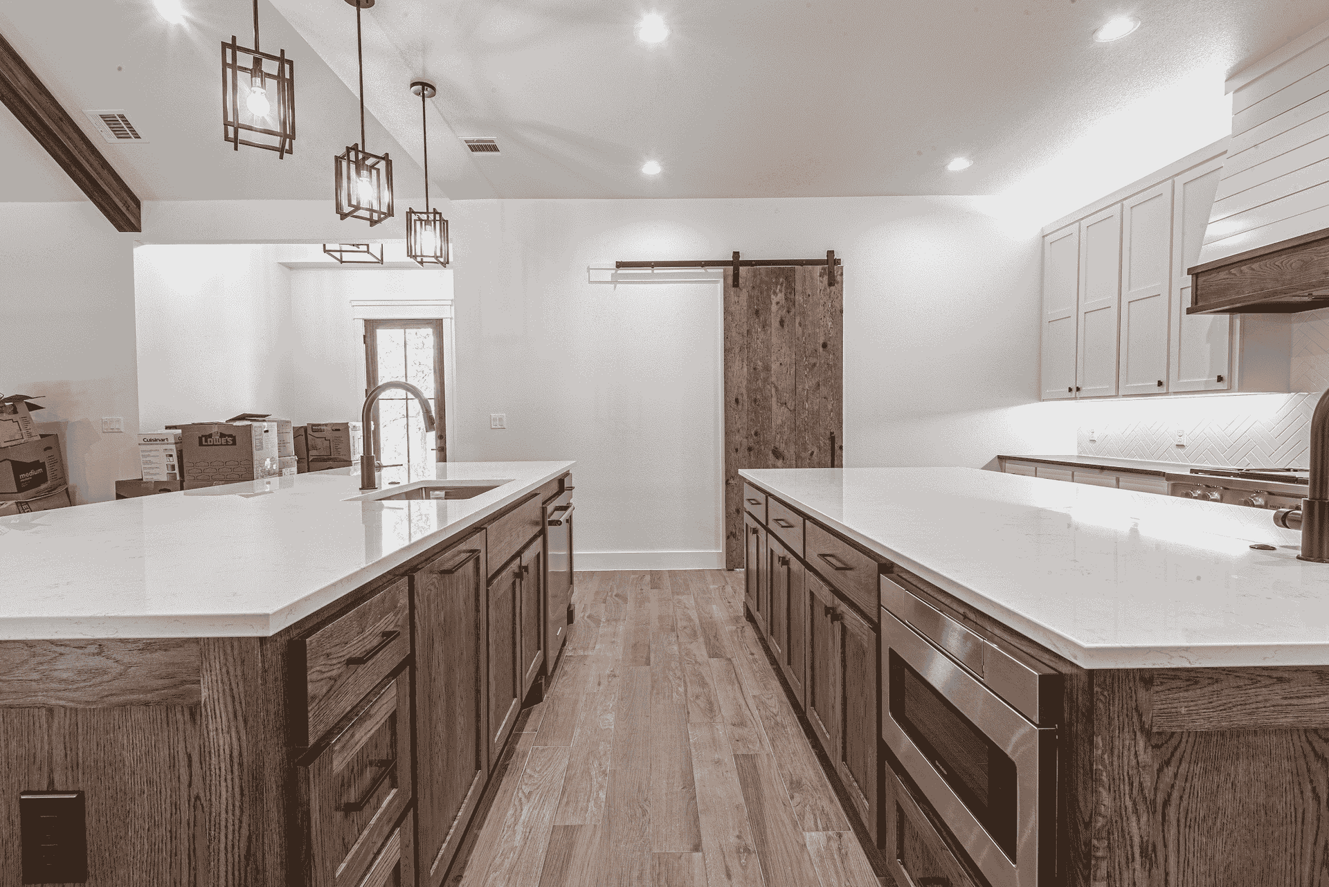 A black and white photo of a kitchen with a sliding barn door.