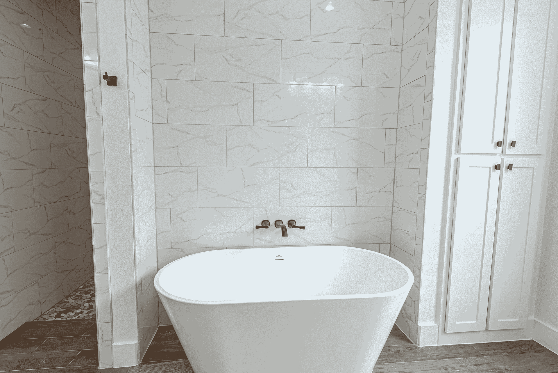 A white bathtub is sitting in a bathroom next to a shower.