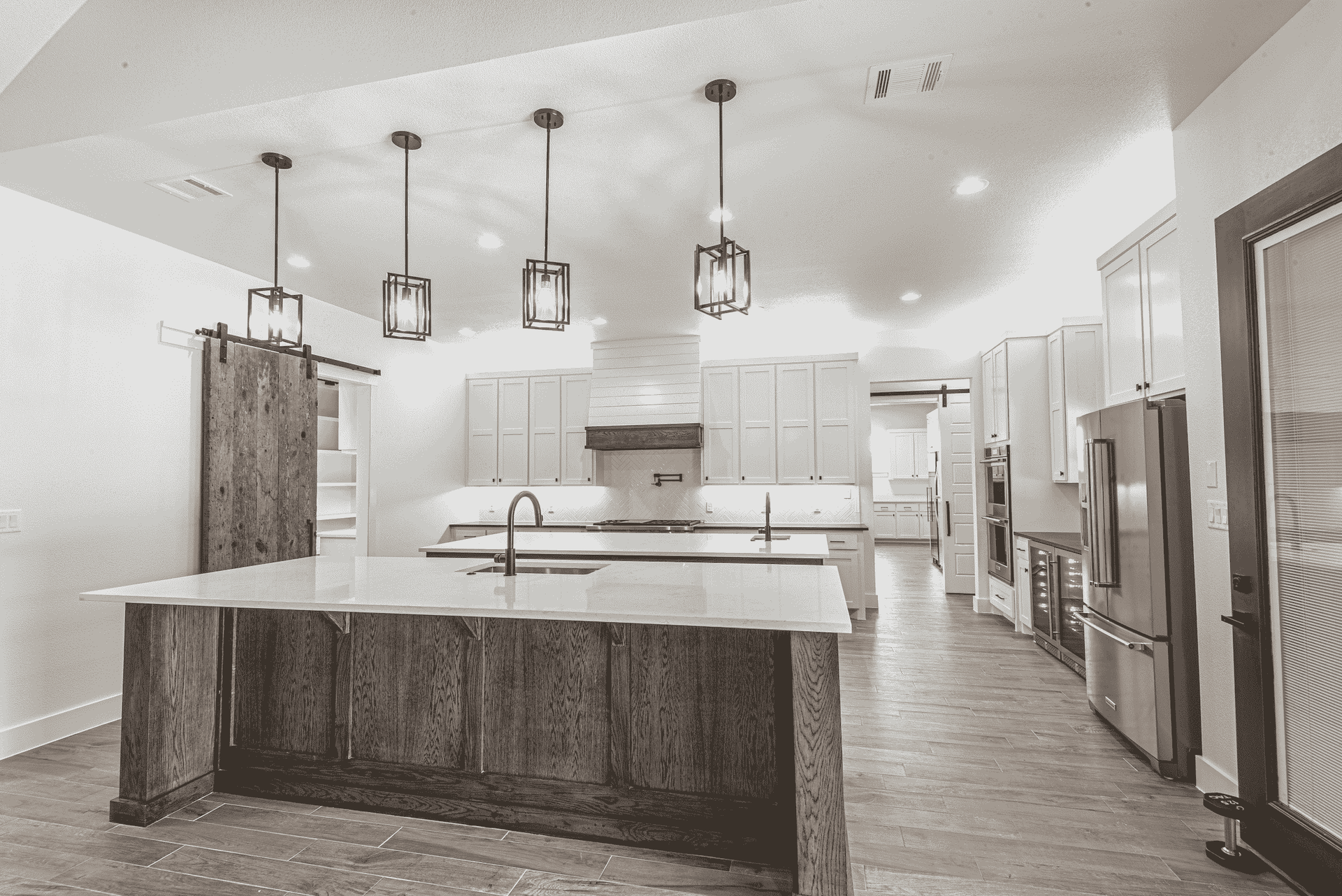 A black and white photo of a kitchen with a large island.