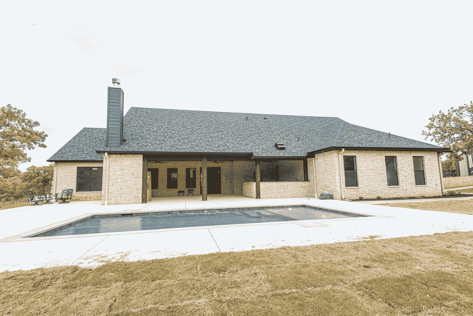 A large house with a swimming pool in front of it.