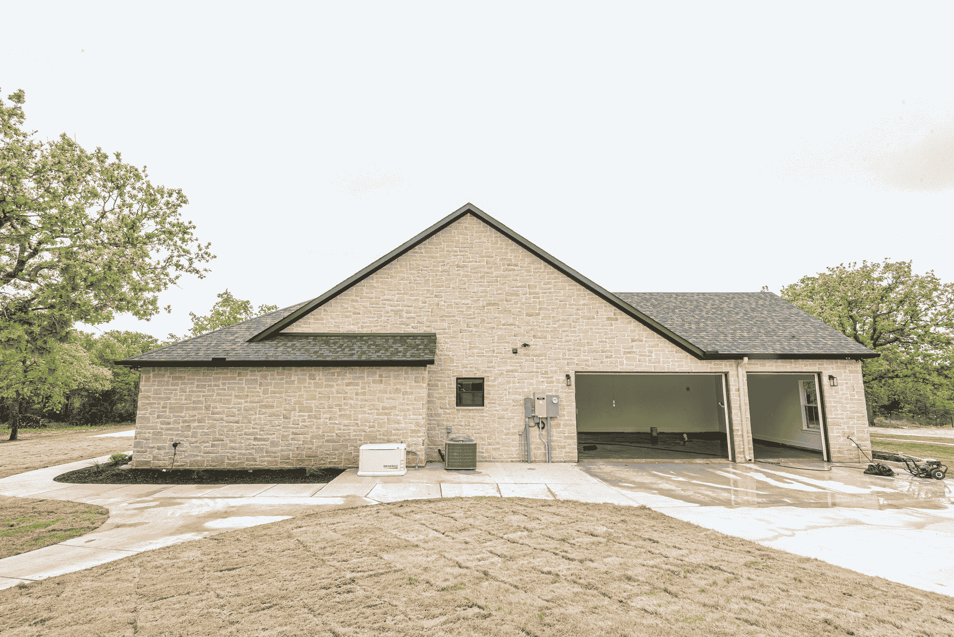 A brick house with a garage and a walkway in front of it.
