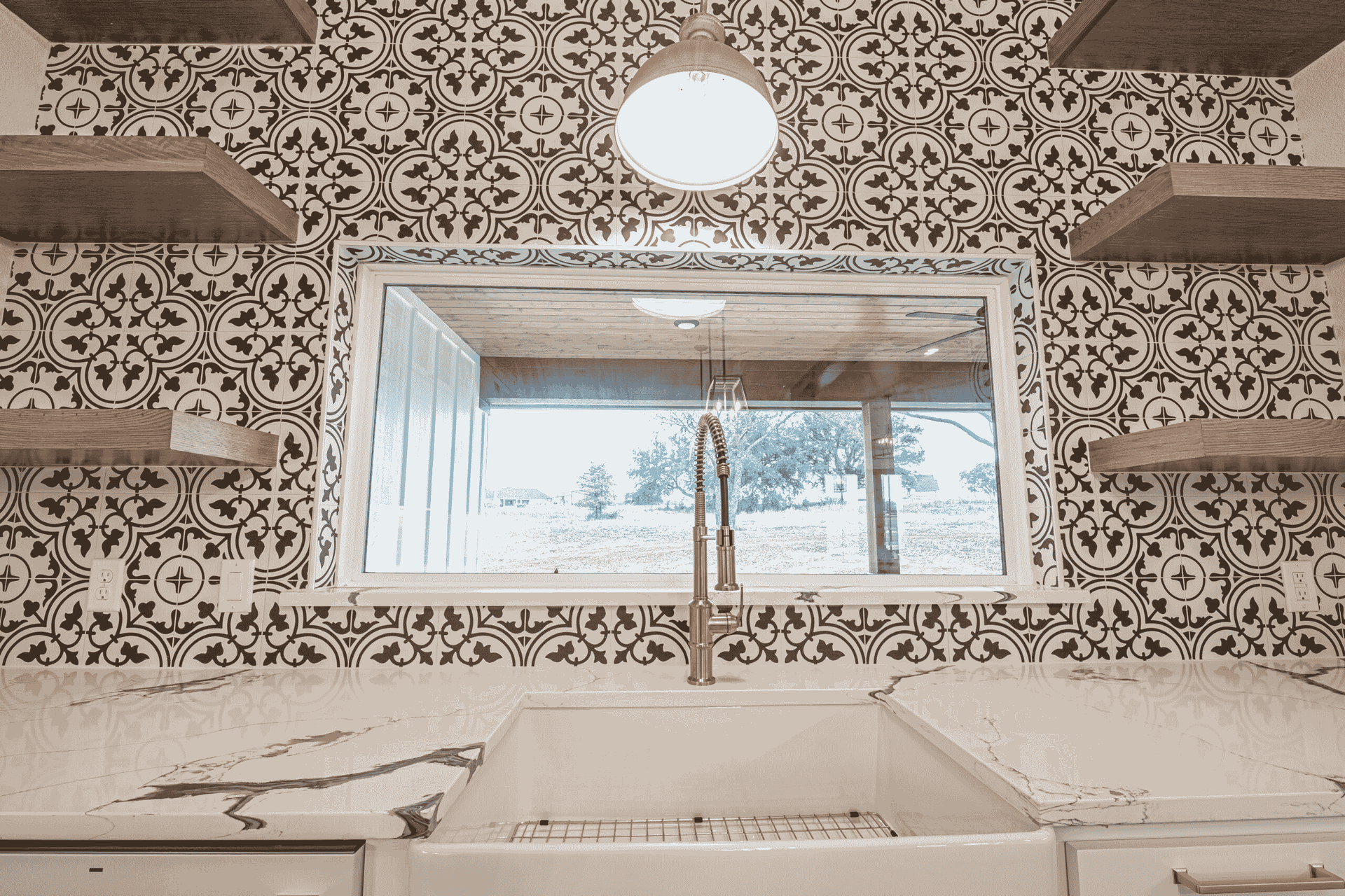 A kitchen with a sink and a mirror on the wall.