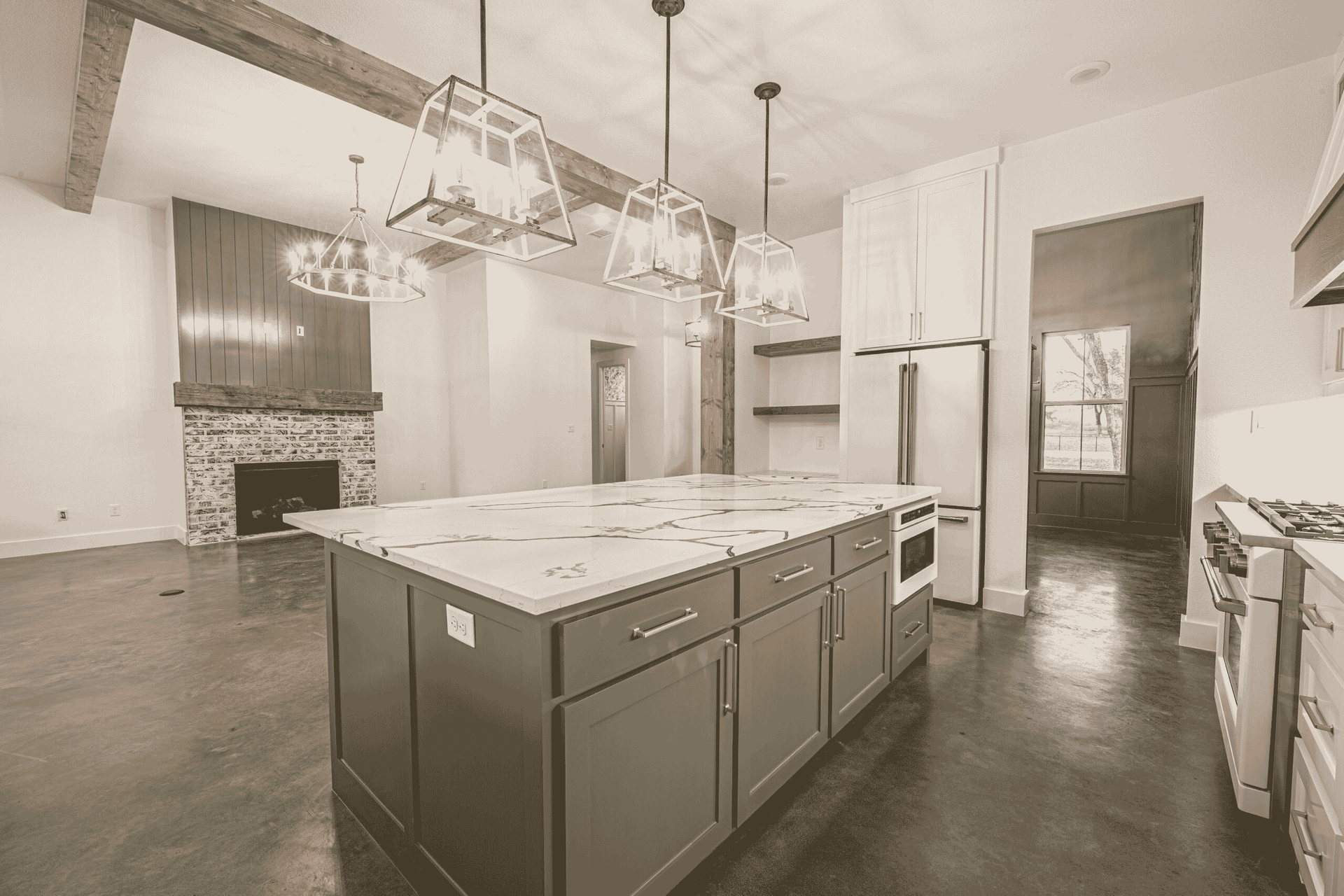 A black and white photo of a kitchen with a large island in the middle.