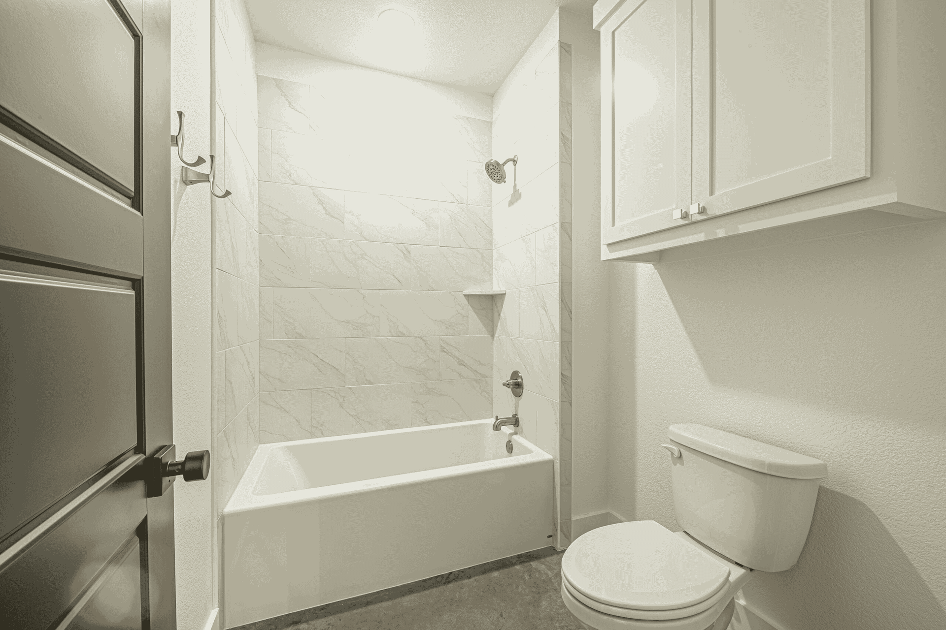 A bathroom with a toilet , bathtub and shower.