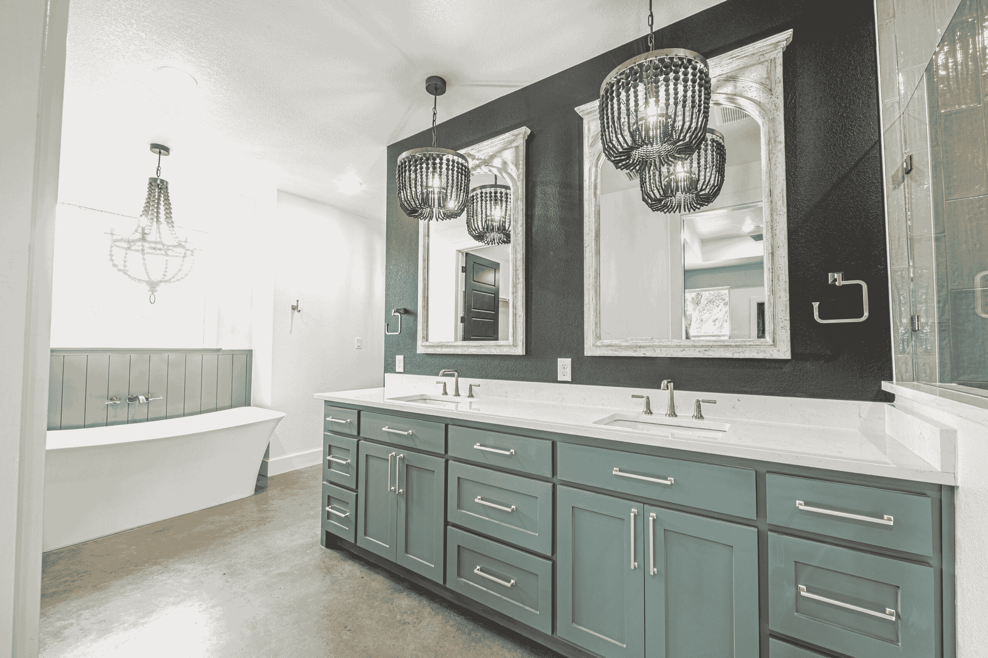 A bathroom with two sinks , two mirrors and a bathtub.