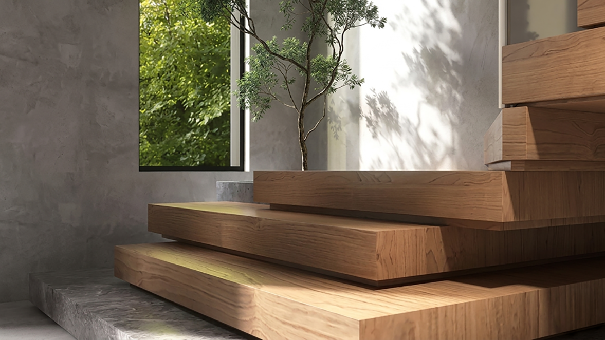 Escalier en bois près d'une fenêtre ensoleillée, avec un petit arbre en pot et des murs gris.