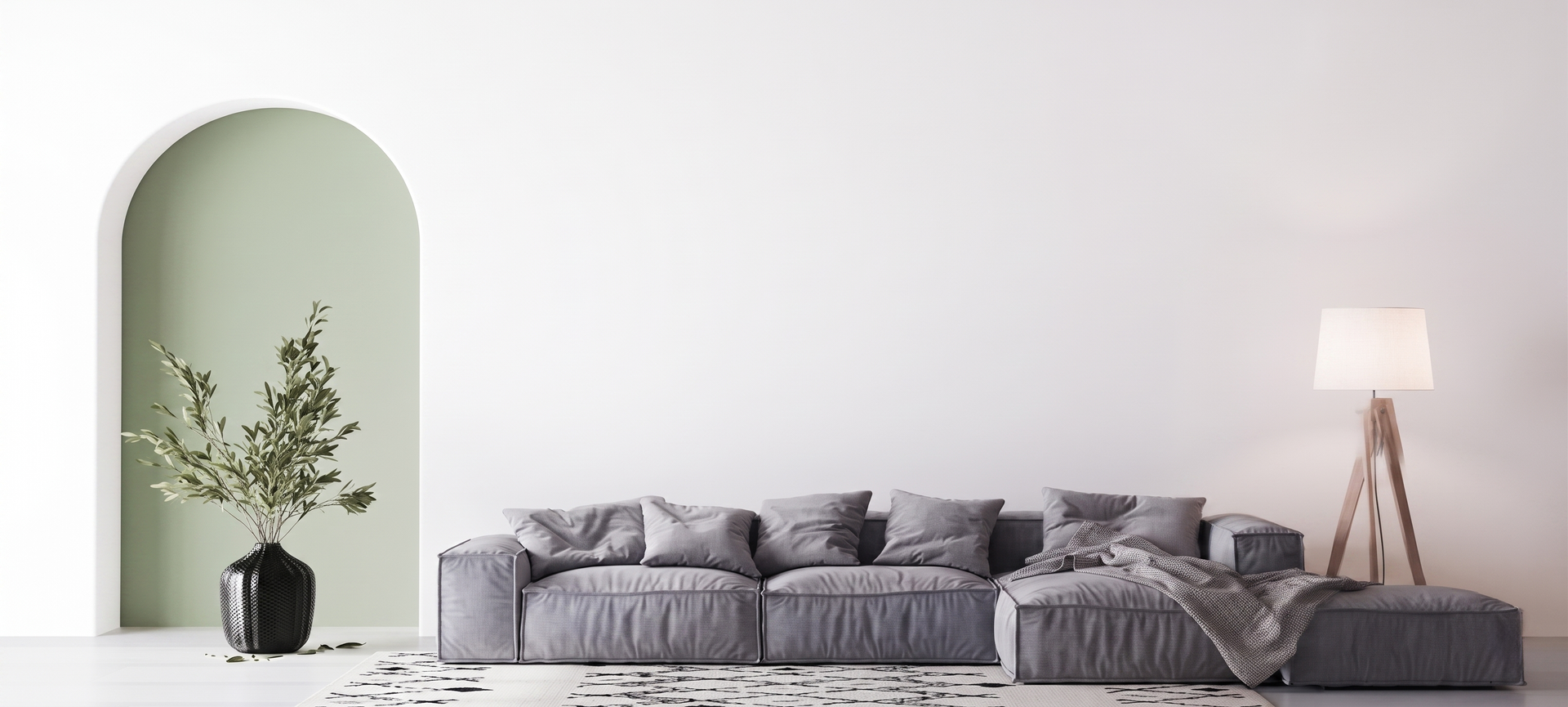 Salon minimaliste avec canapé d'angle gris, vase noir, niche murale cintrée et lampadaire