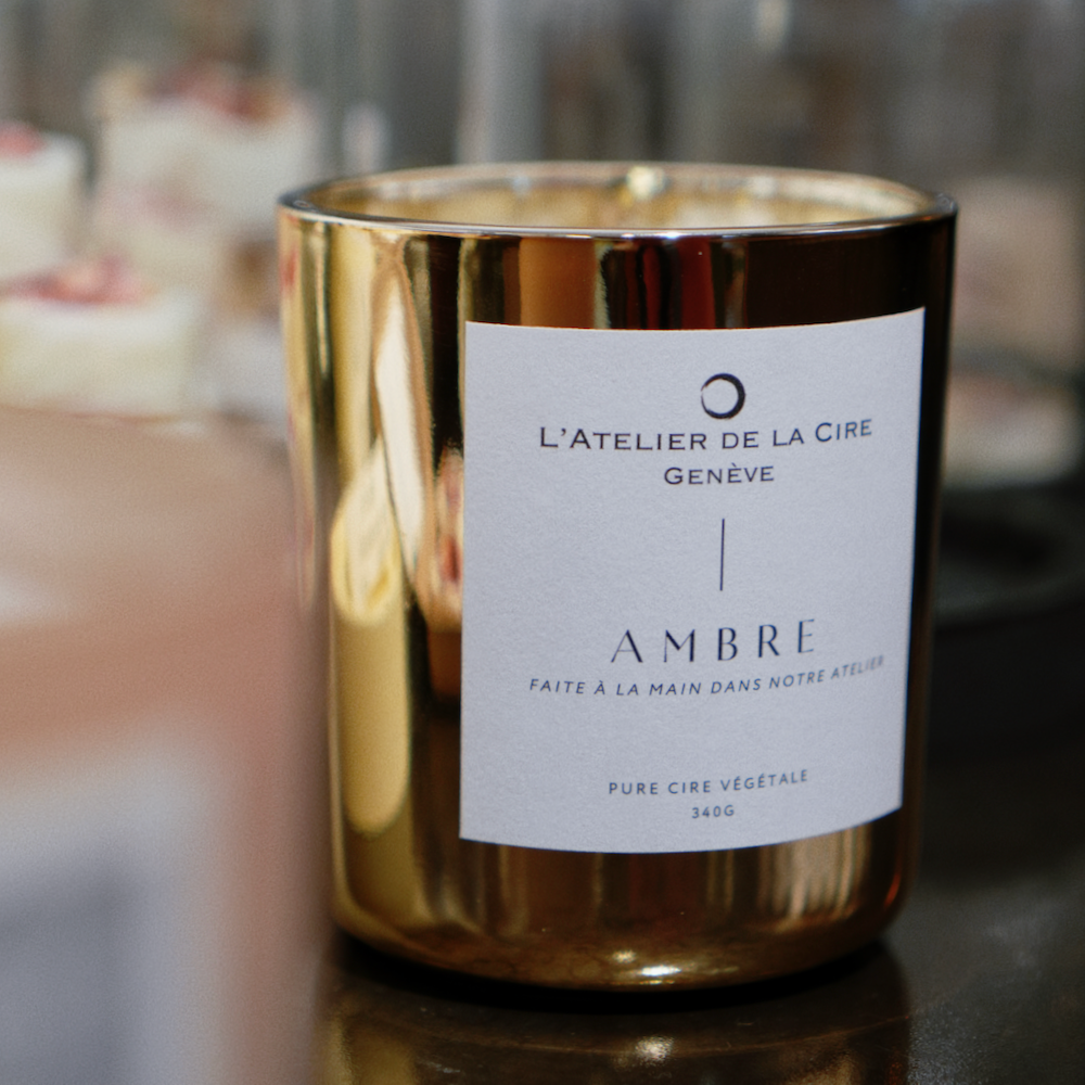 Bougie couleur or dans un récipient en verre avec étiquette blanche 