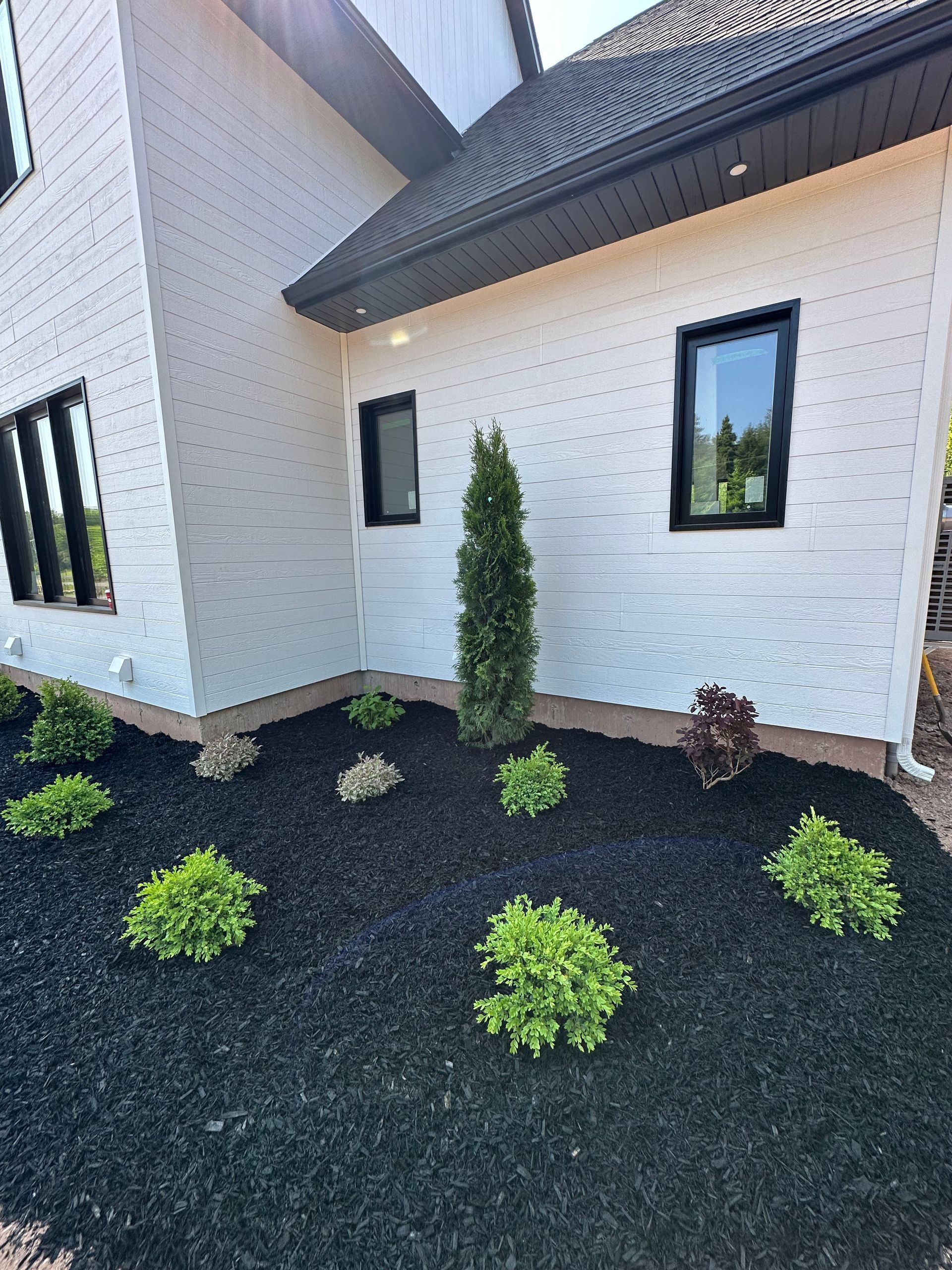 A stone wall with flowers in front of a house.