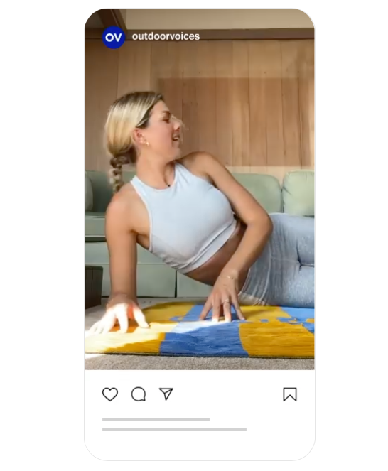 A woman is laying on a yoga mat in a living room.