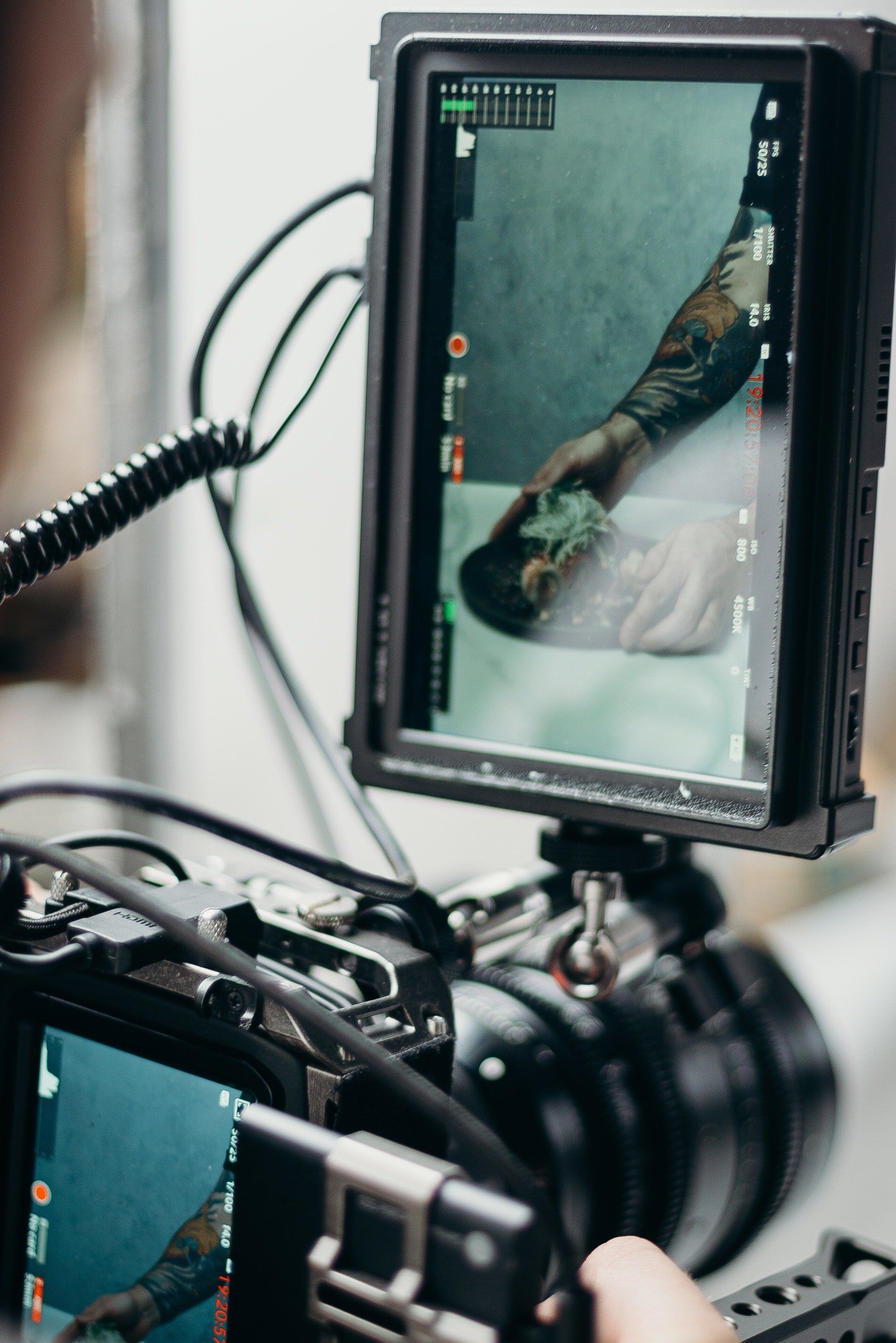 A person is holding a camera with a monitor attached to it.