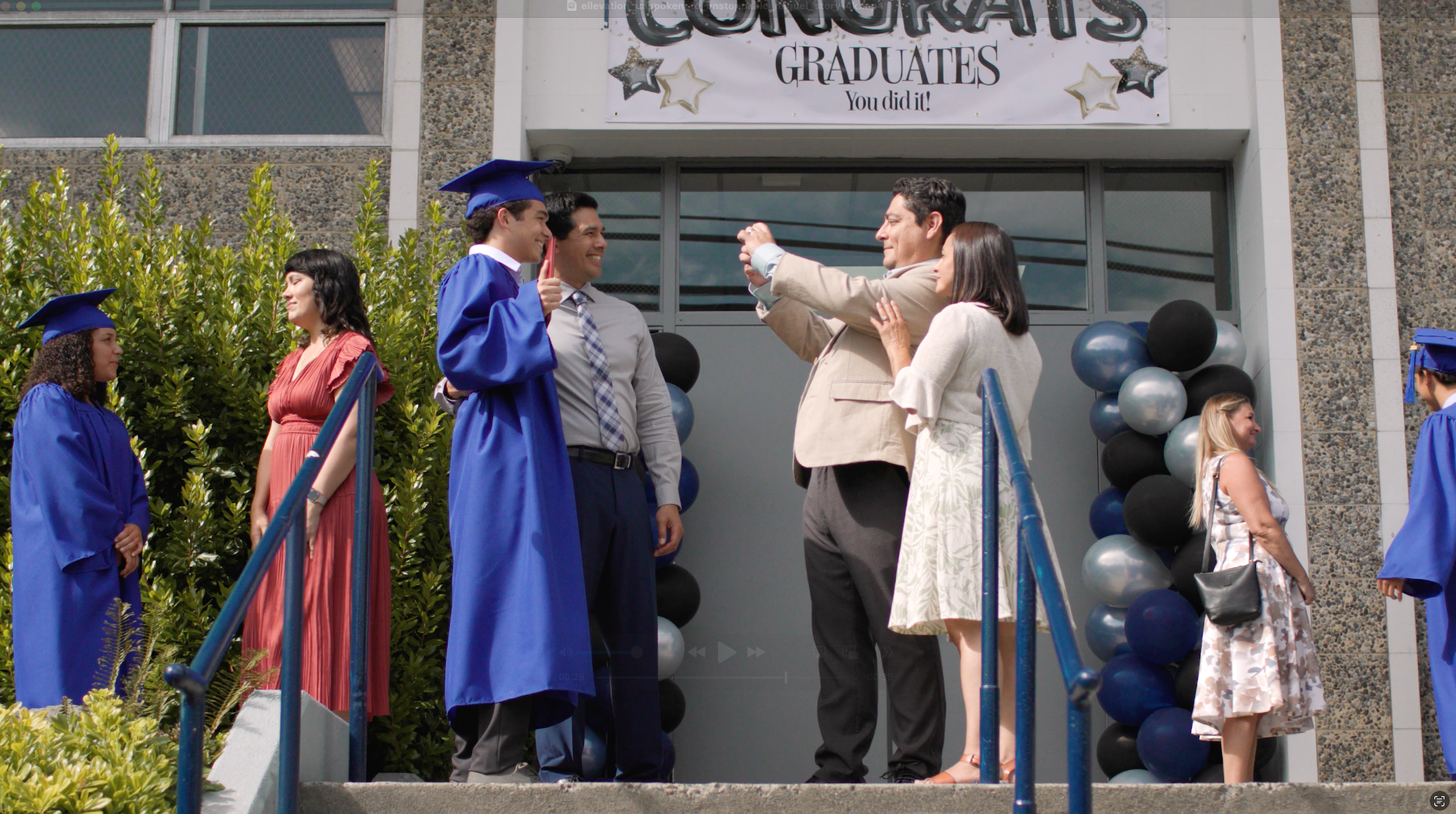 Spin Creative Microsoft Viva Relaunch Graduation celebration outside a building. Graduates and families pose for photos. Blue and white decor.