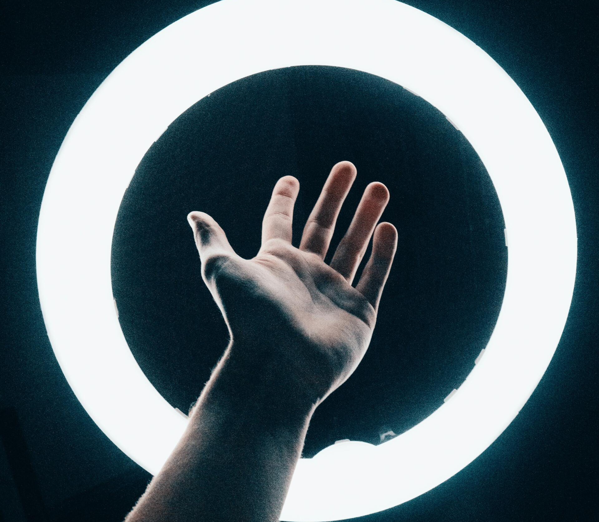 A hand is reaching out towards a white circle