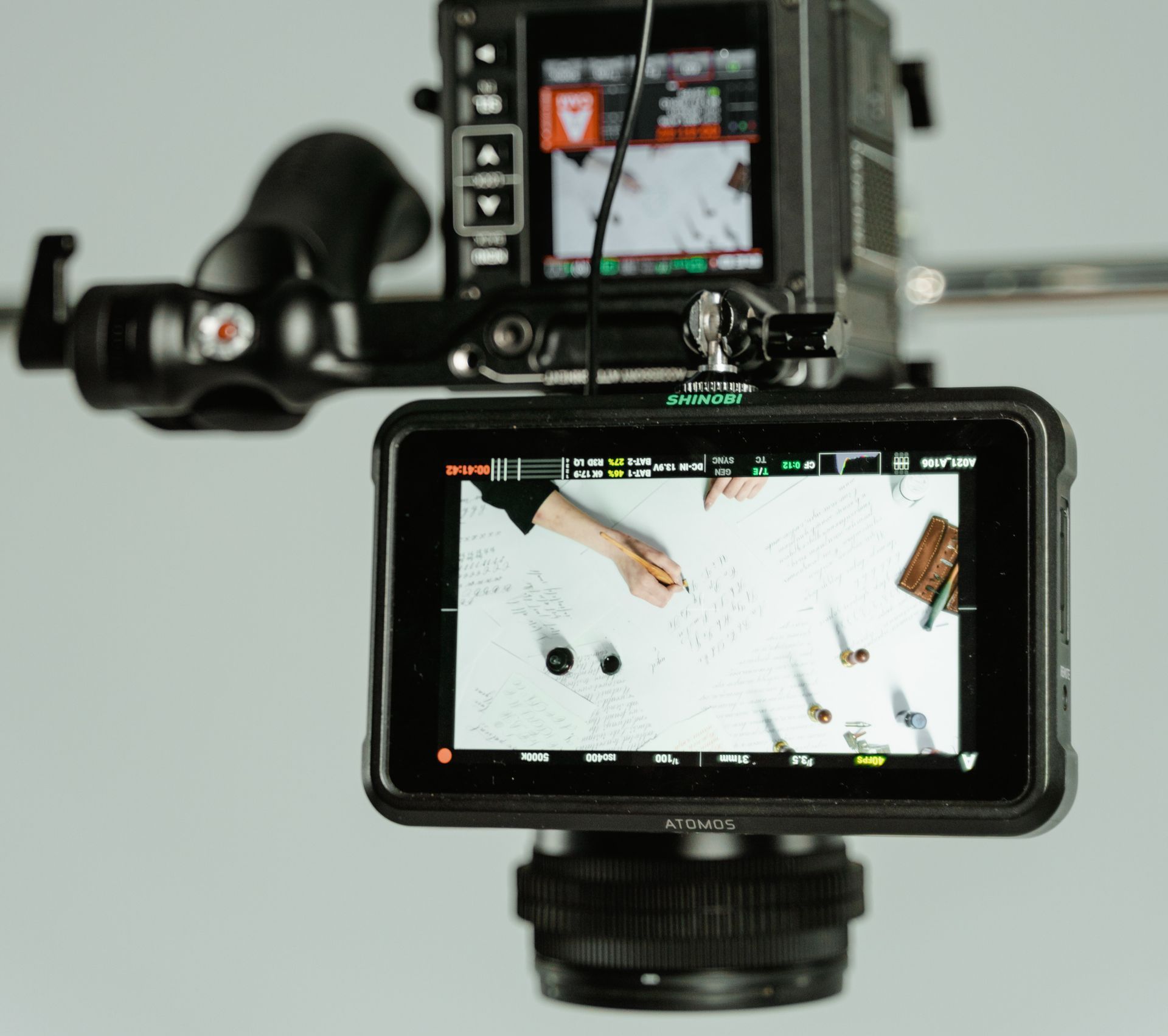 Camera setup filming overhead; top-down view of hands arranging items.