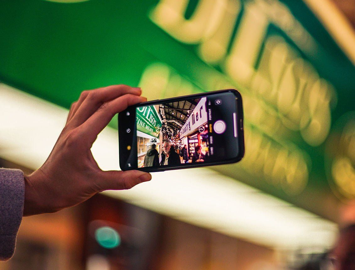 close up hand holding mobile phone A person is taking a picture with a cell phone.