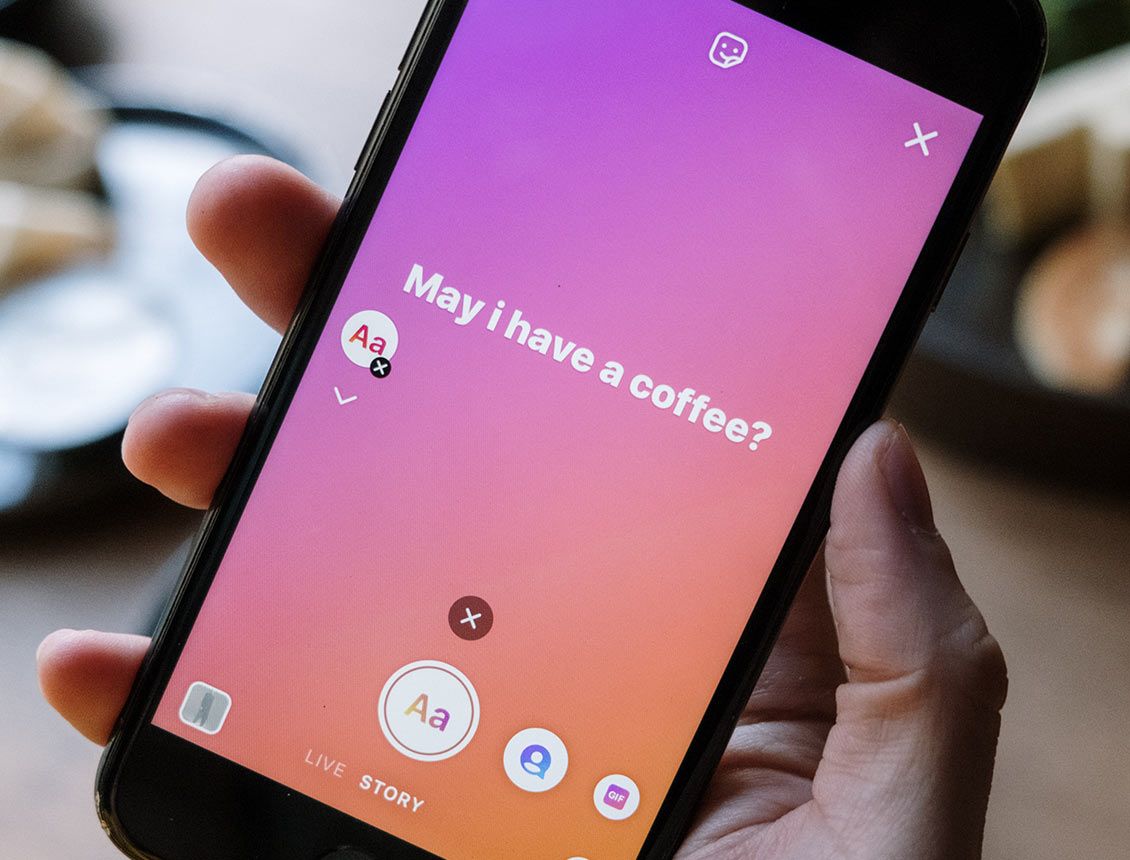 close up phone showing ig story screen with text writing on screen A person is holding a cell phone that says may i have a coffee