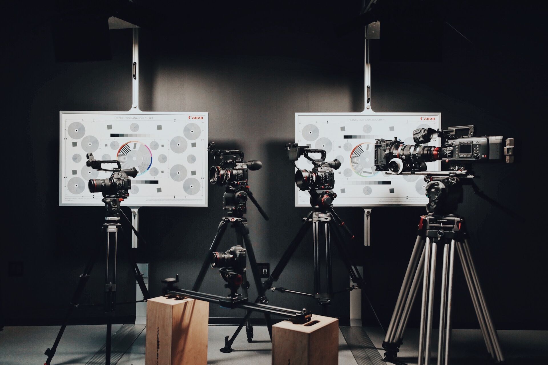 Multiple cinema cameras on tripods in studio Two cameras are on tripods in a dark room