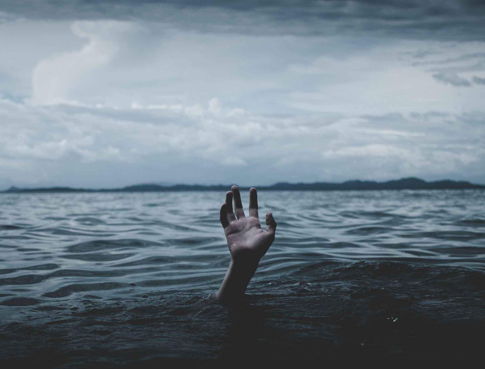 Hand reaching out of water A hand is sticking out of the water.