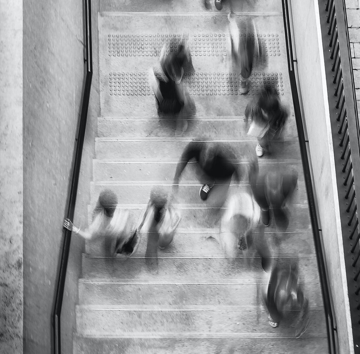 A black and white photo of people walking down stairs