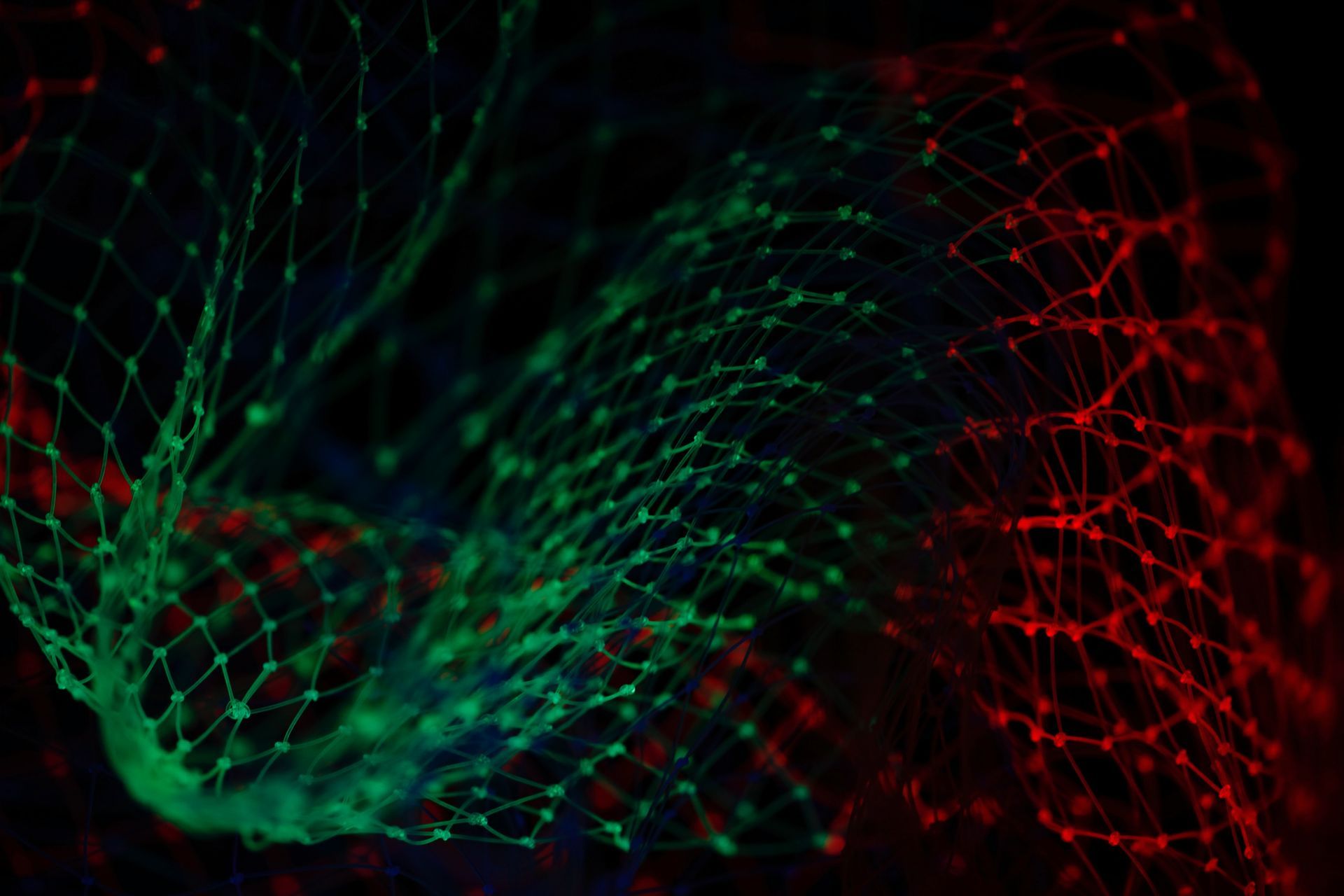 A green and red swirl of lines and dots on a black background.