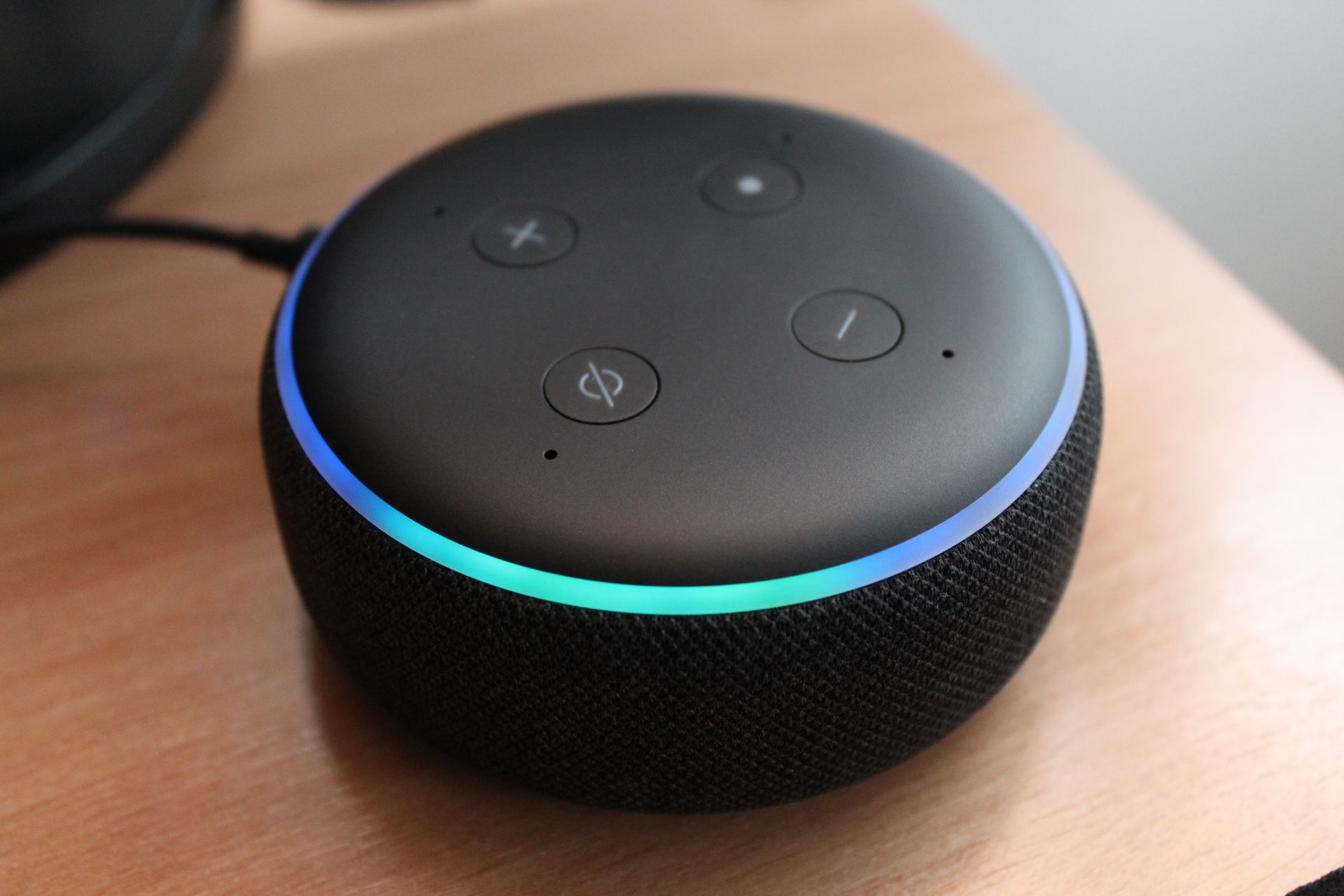 Amazon Alexa close up on table A small black device with a blue light around it