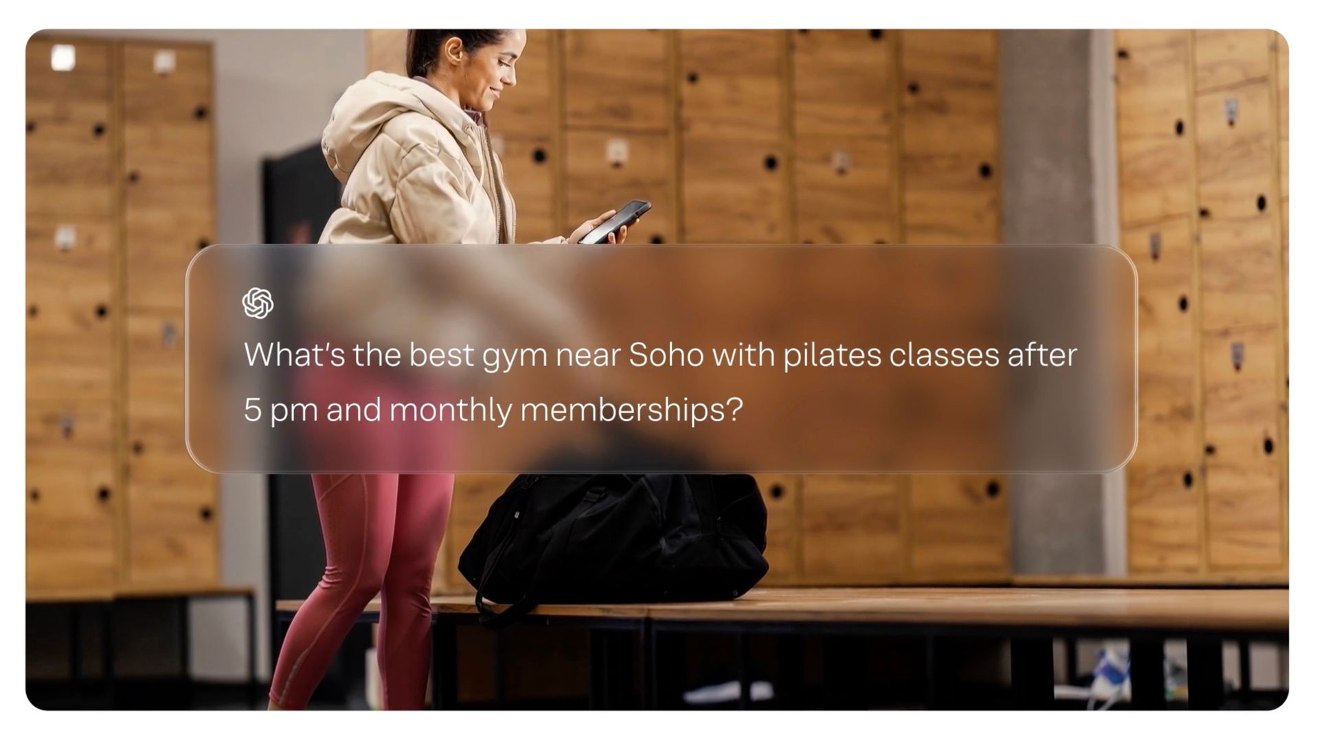 Person walking past stacked wooden boxes in a gym locker room, looking at a phone, from the Yext Be the Answer brand film.
