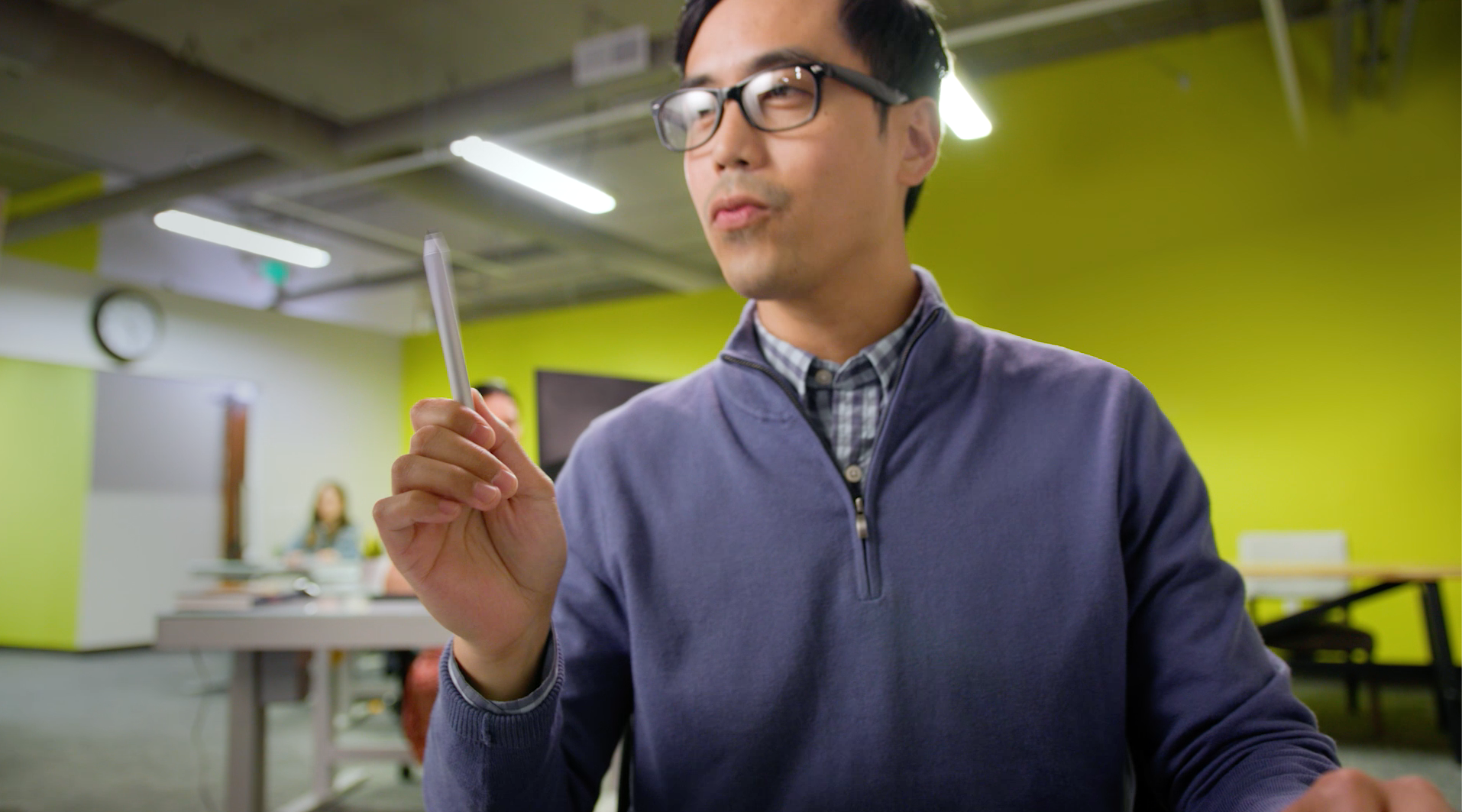 Spin Creative Microsoft Viva Relaunch A man wearing glasses is holding a pen in his hand.