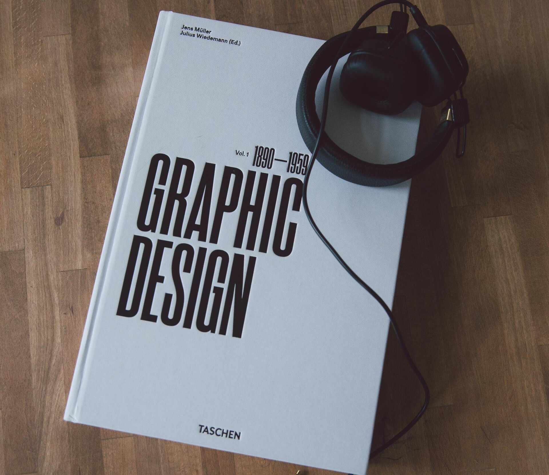 A graphic design book with headphones on top of it