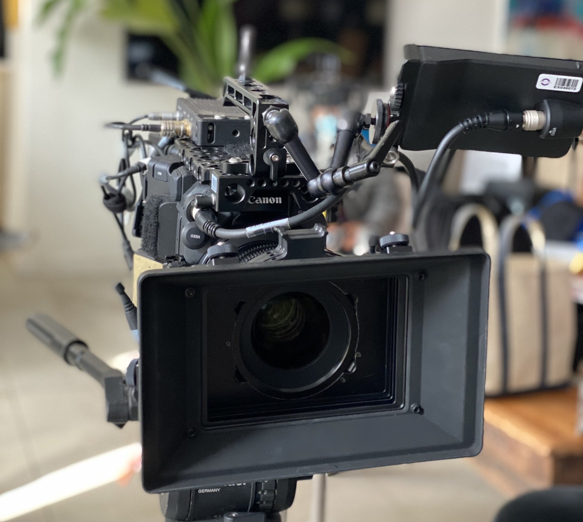 Behind the scenes Spin Creative video production on location filming with the Canon C300 cinema camera Professional film camera with matte box on tripod, indoors.