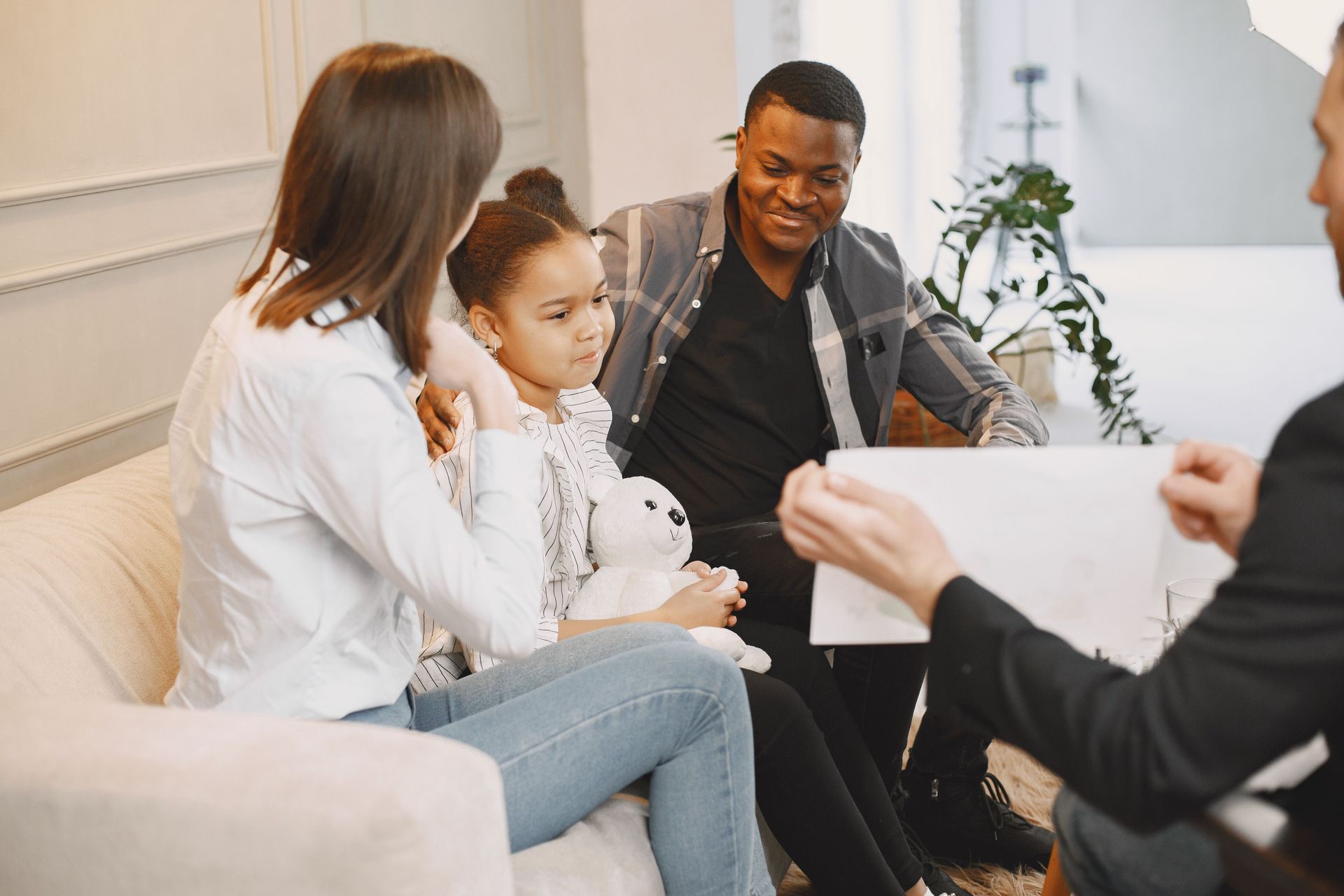 Small group in a bright office meeting, seated on a couch and talking with a seated interviewer.