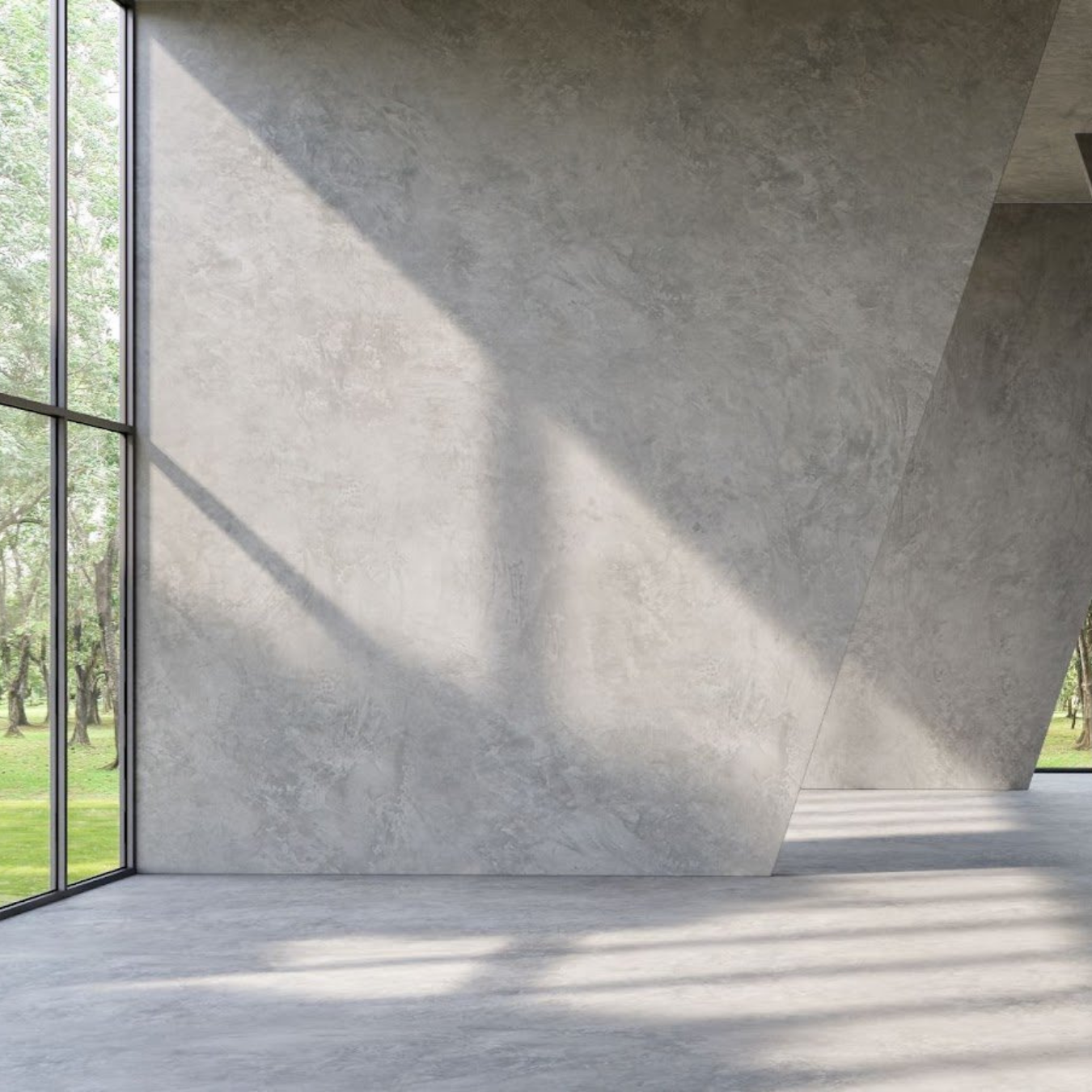 An empty room with a large window and a concrete wall.
