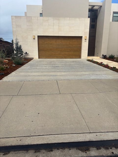 A driveway leading to a large house with a wooden garage door.