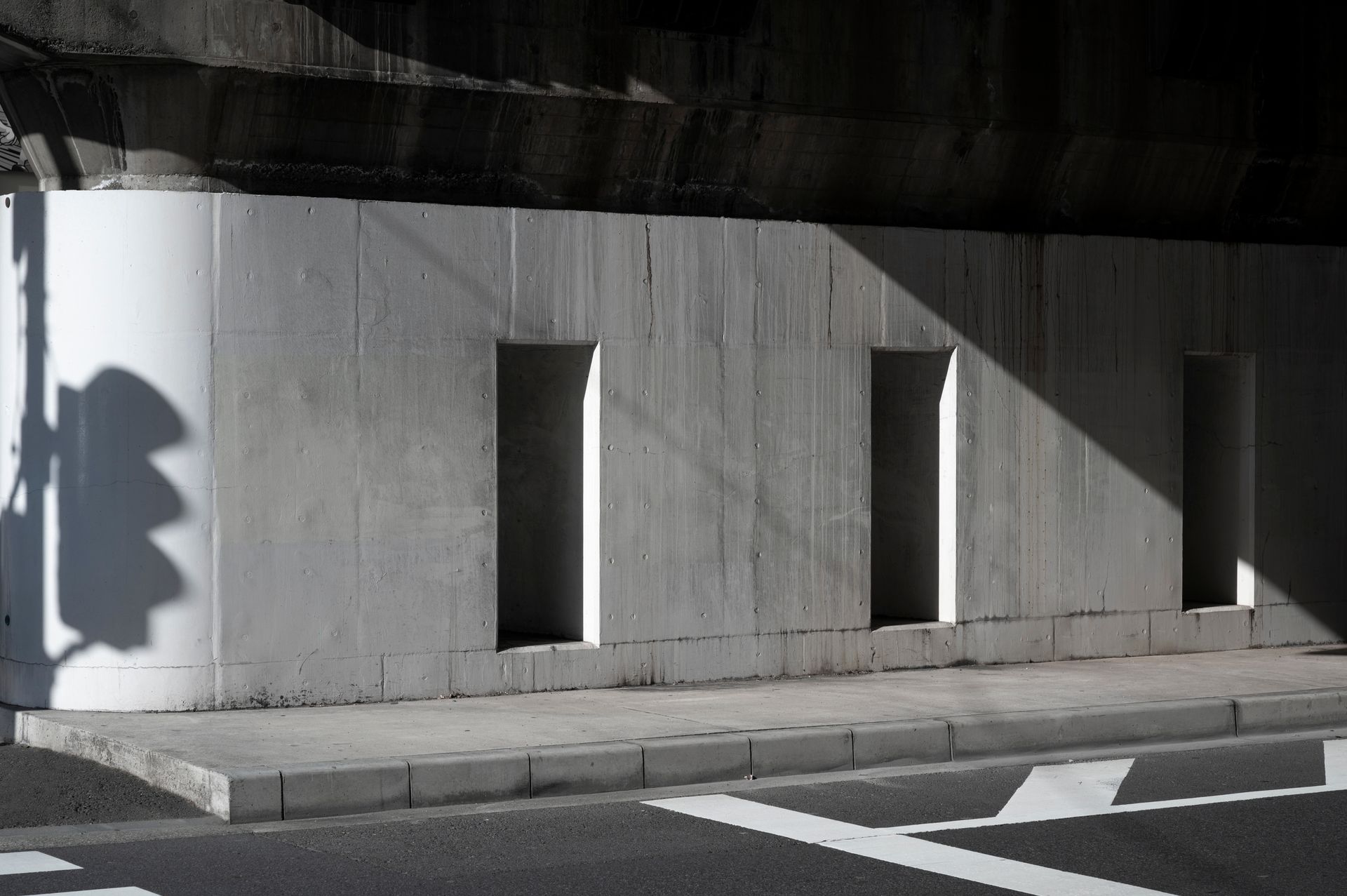 A shadow of a person is cast on a concrete wall