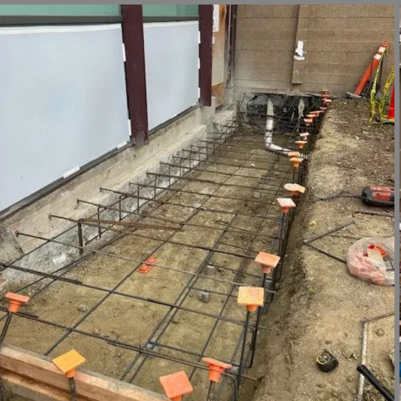 A concrete foundation is being built with steel bars.