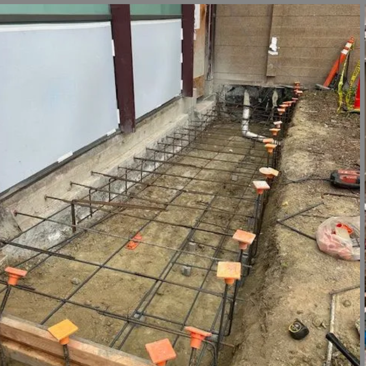 A concrete foundation is being built with steel bars.