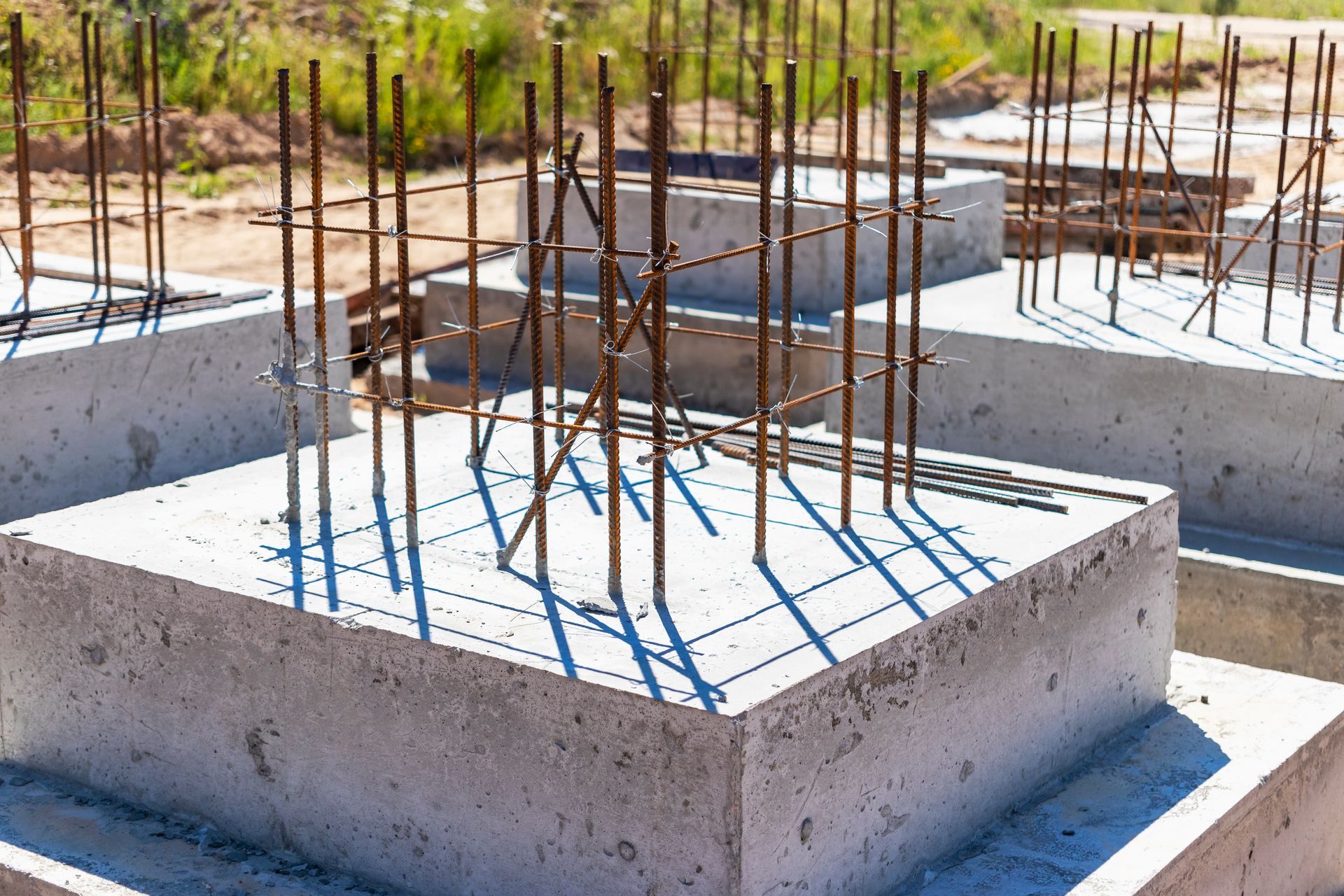 A concrete base for a building under construction with metal bars.